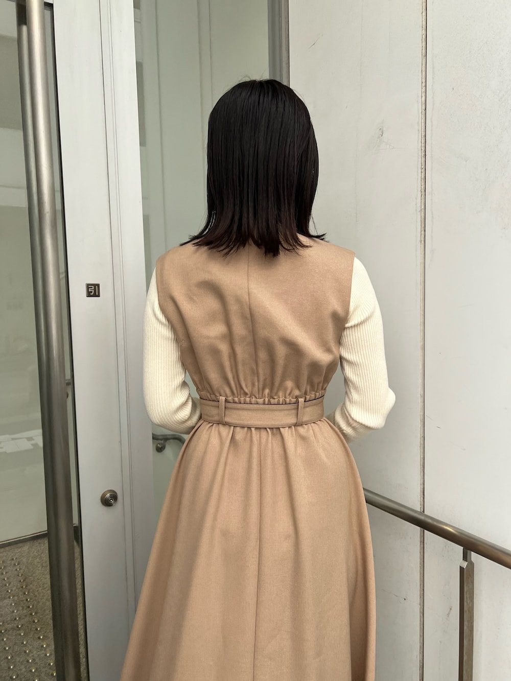 ベージュ系のトレンチコート、ホワイト系のショルダーバッグ、ホワイト系のニット/セーターを着用したレディースの秋コーディネートの9枚目の写真