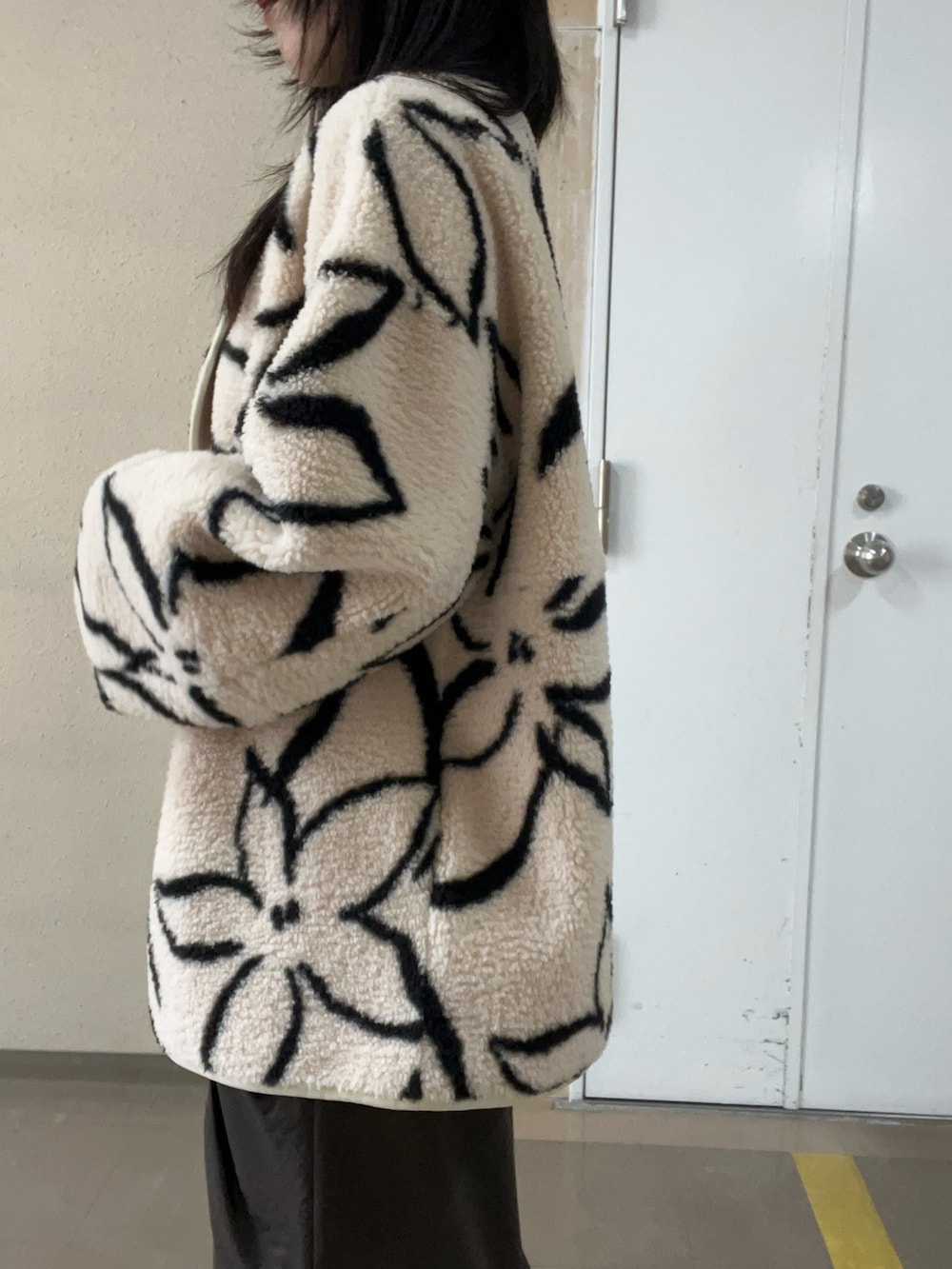 ブラック系のブーツ、ホワイト系のブルゾン、ブラック系のニット/セーターを着用したレディースの秋コーディネートの5枚目の写真