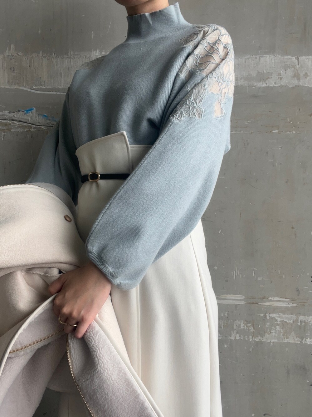 ベージュ系のブーツ、ホワイト系のハンドバッグ、ホワイト系のムートンコートを着用したレディースの秋コーディネートの7枚目の写真