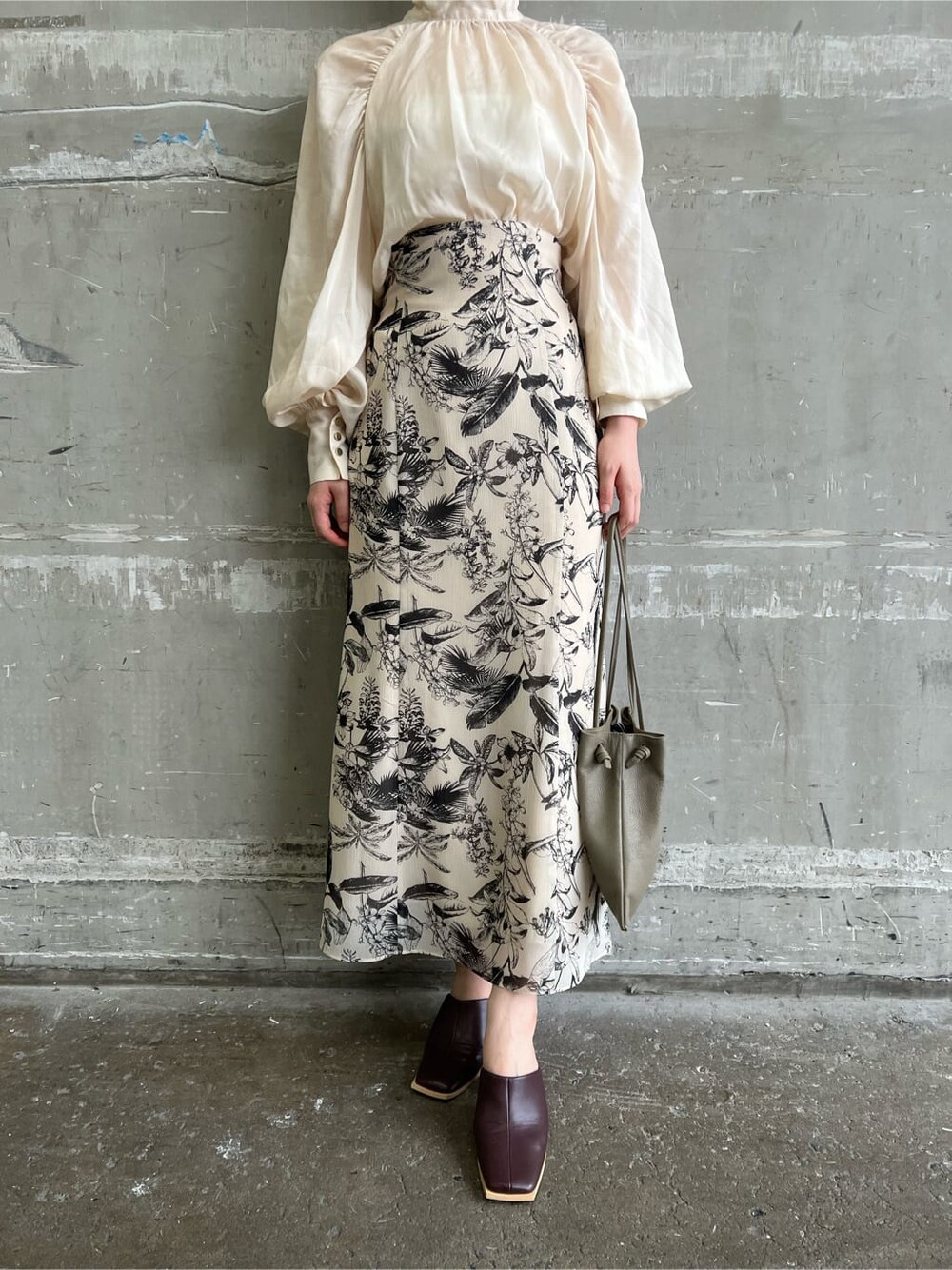 ベージュ系のハンドバッグ、ベージュ系のスカート、ブラウン系のシャツ/ブラウスを着用したレディースの夏コーディネートの8枚目の写真