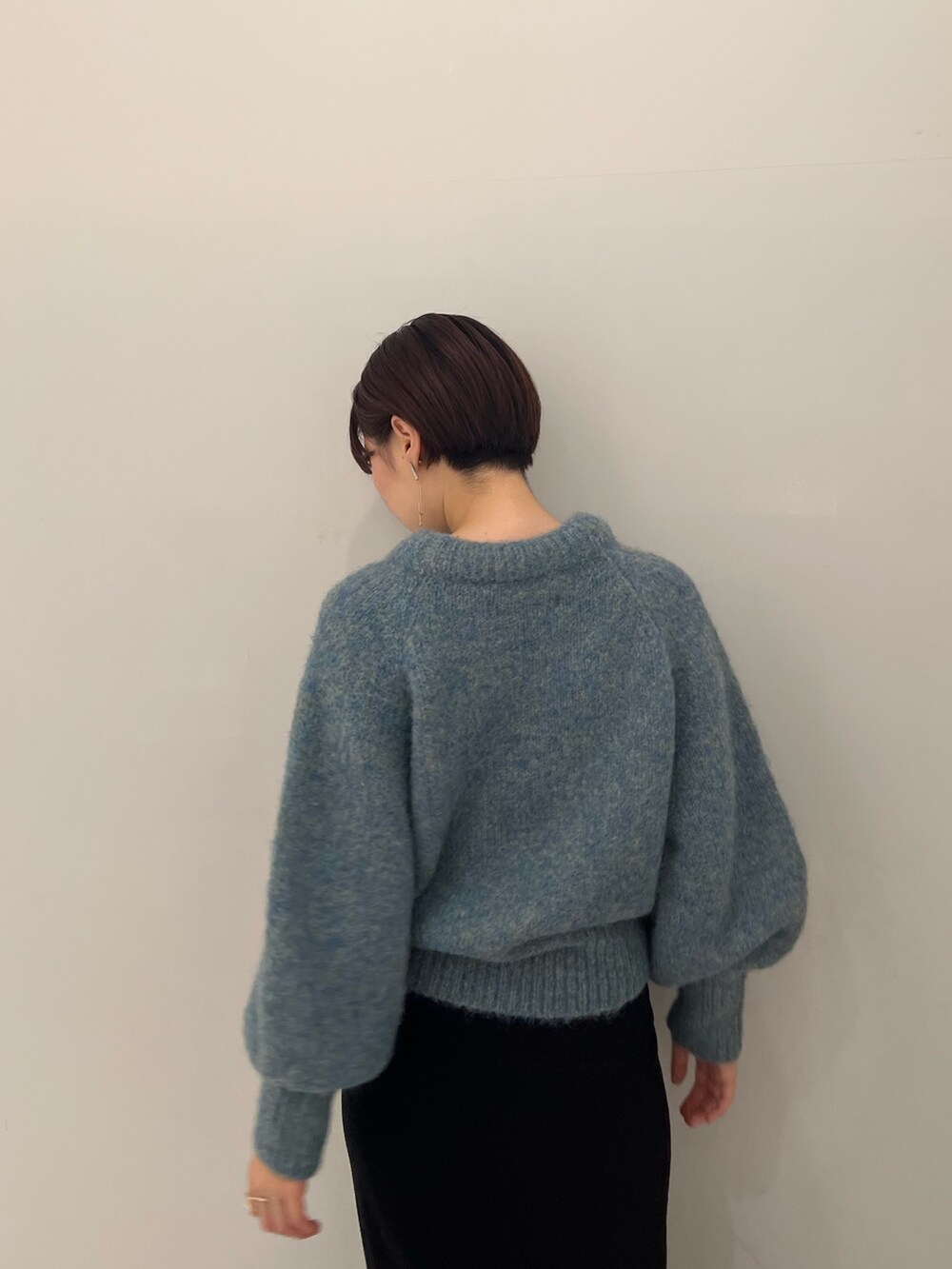 ベージュ系のブーツ、ブラック系のスカート、グリーン系のニット/セーターを着用したレディースの冬コーディネートの6枚目の写真