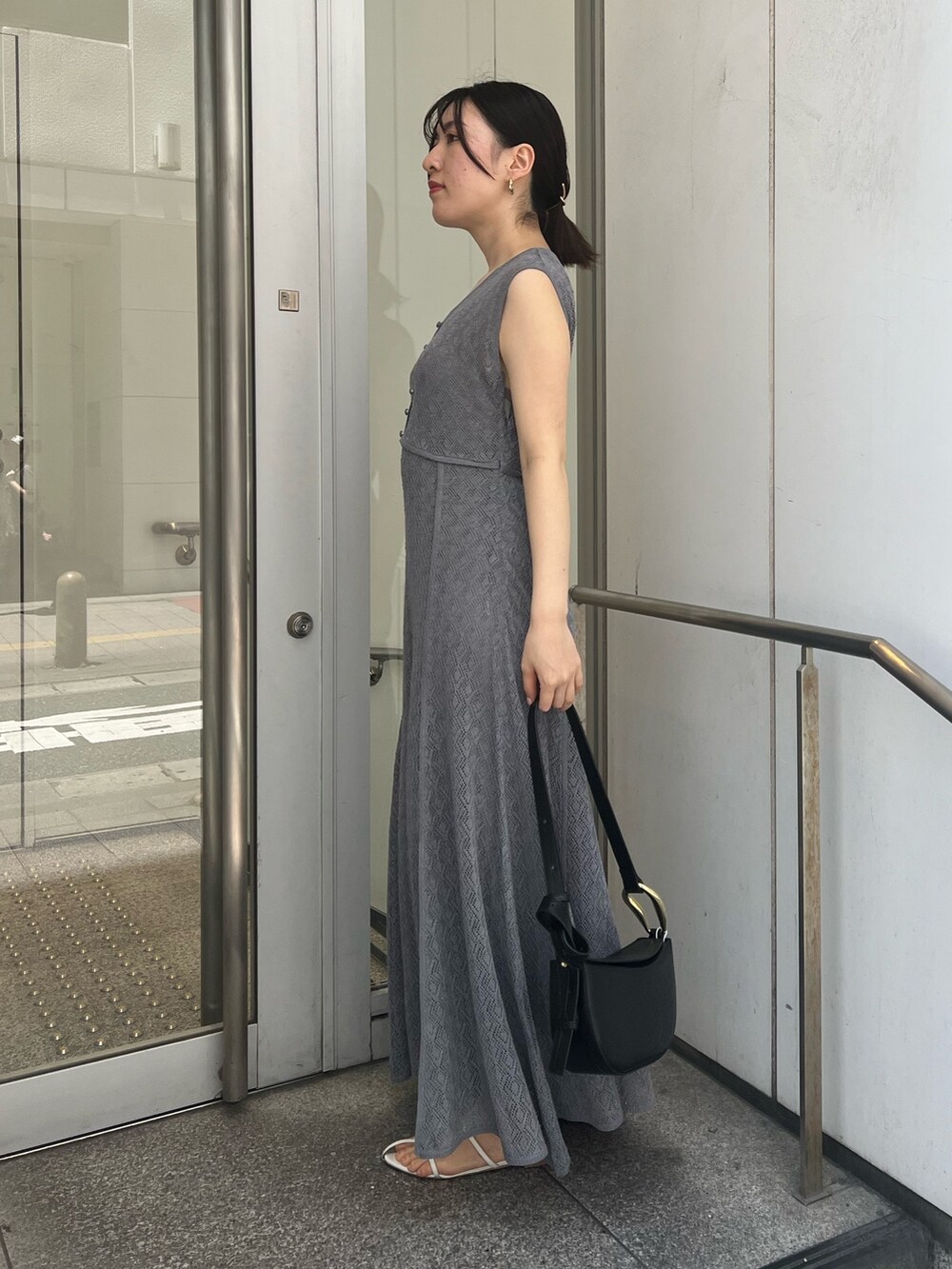 ブラック系のショルダーバッグ、グレー系のワンピースを着用したレディースの夏コーディネートの2枚目の写真