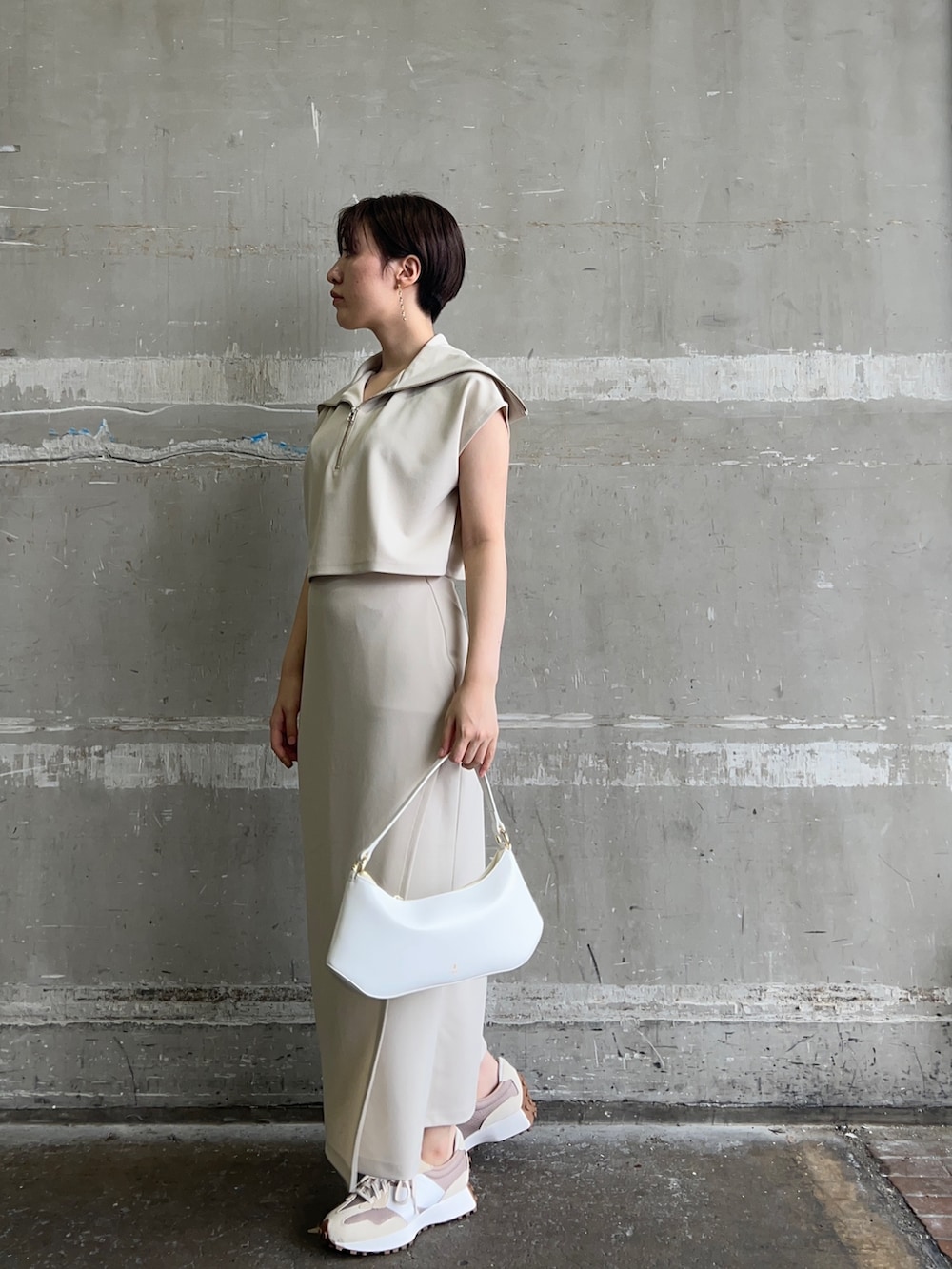 ホワイト系のハンドバッグ、ホワイト系のTシャツ/カットソー、ホワイト系のスカートを着用したレディースの夏コーディネートの2枚目の写真