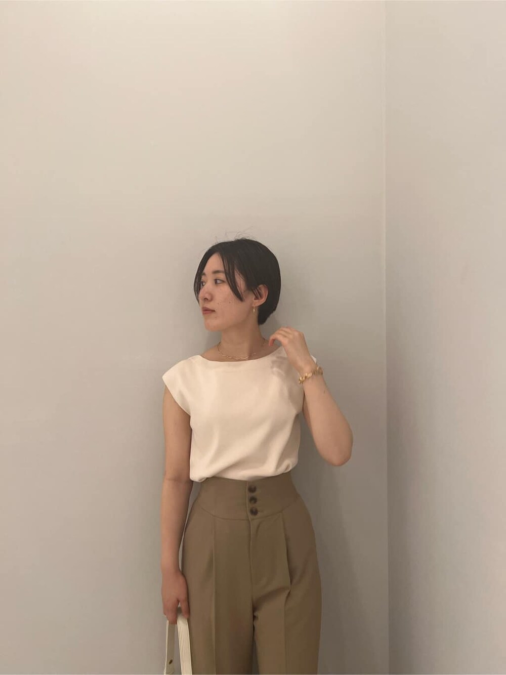 ベージュ系のその他パンツ、ホワイト系のニット/セーター、ホワイト系のショルダーバッグを着用したレディースの夏コーディネートの7枚目の写真