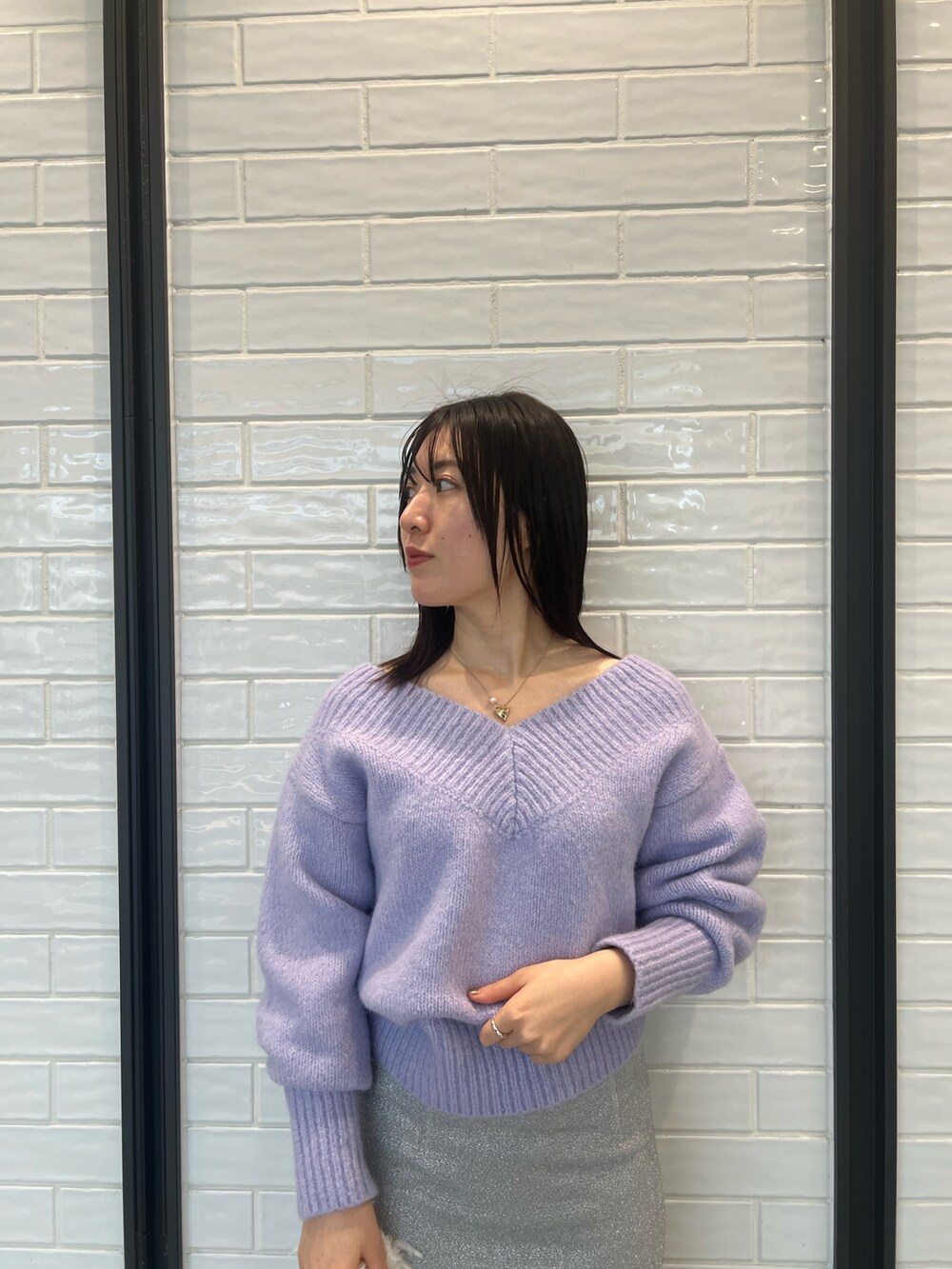 パープル系のニット/セーター、シルバー系のスカートを着用したレディースの冬コーディネートの4枚目の写真