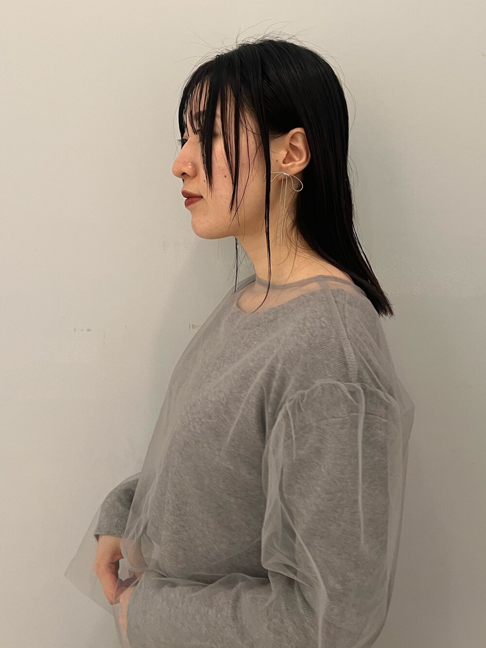 グレー系のワンピース、ブラック系のブーツ、ブラック系のショルダーバッグを着用したレディースの冬コーディネートの5枚目の写真