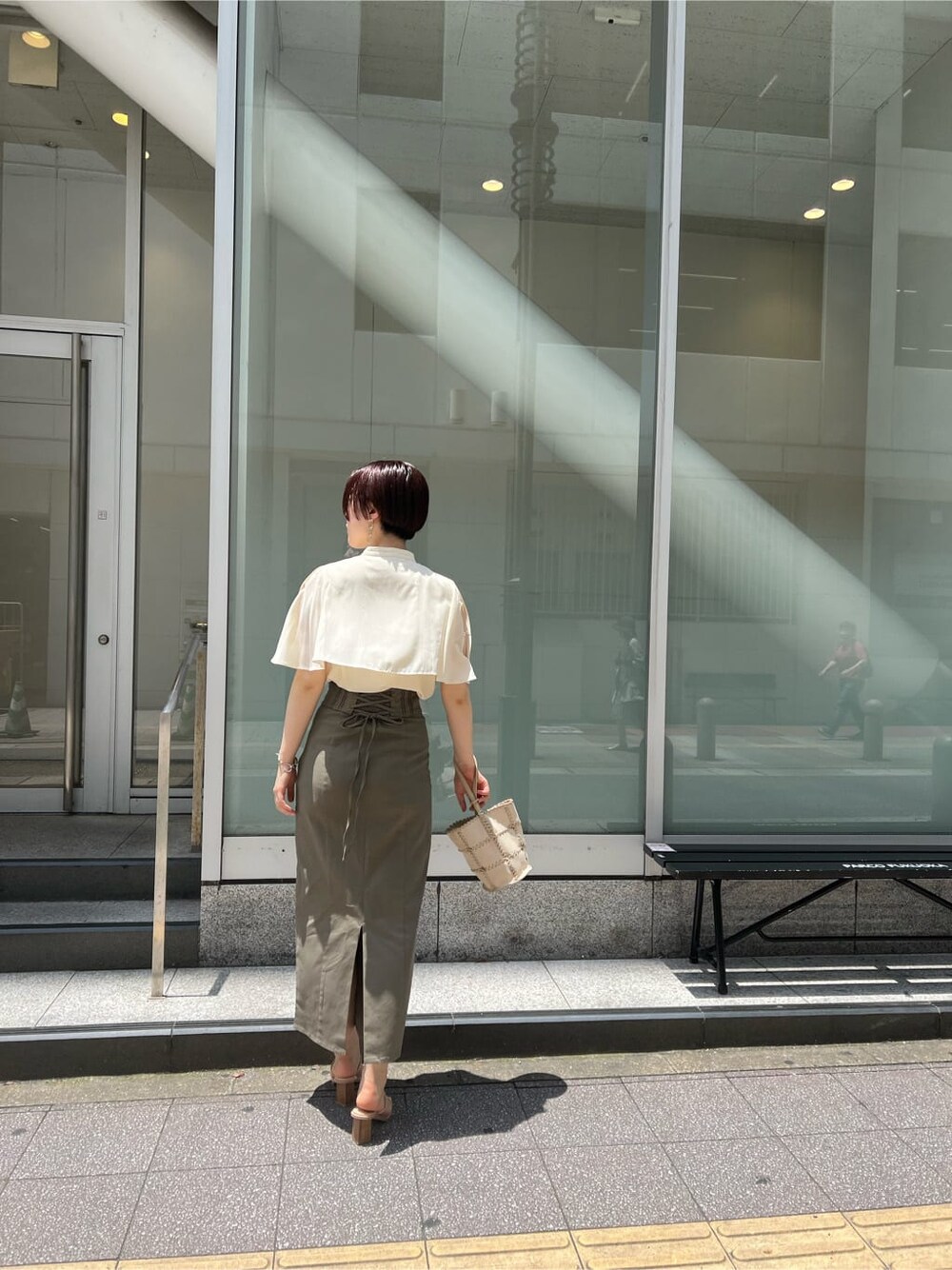 グリーン系のサンダル、ベージュ系のスカート、ホワイト系のショルダーバッグを着用したレディースの夏コーディネートの2枚目の写真