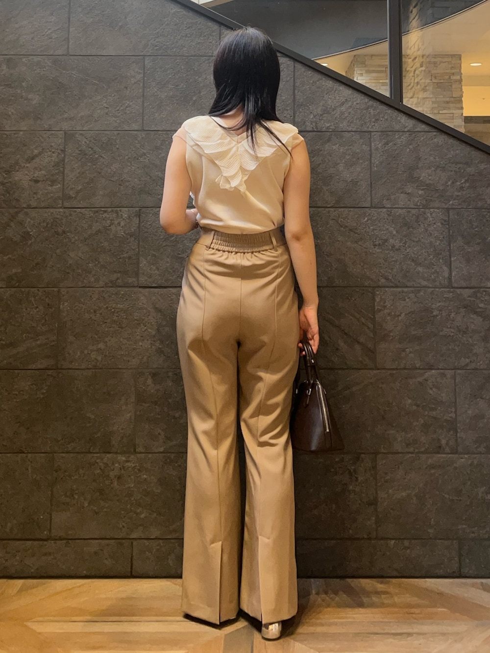 ブラウン系のボストンバッグ、ホワイト系のニット/セーター、ブラウン系のボストンバッグを着用したレディースの秋コーディネートの3枚目の写真