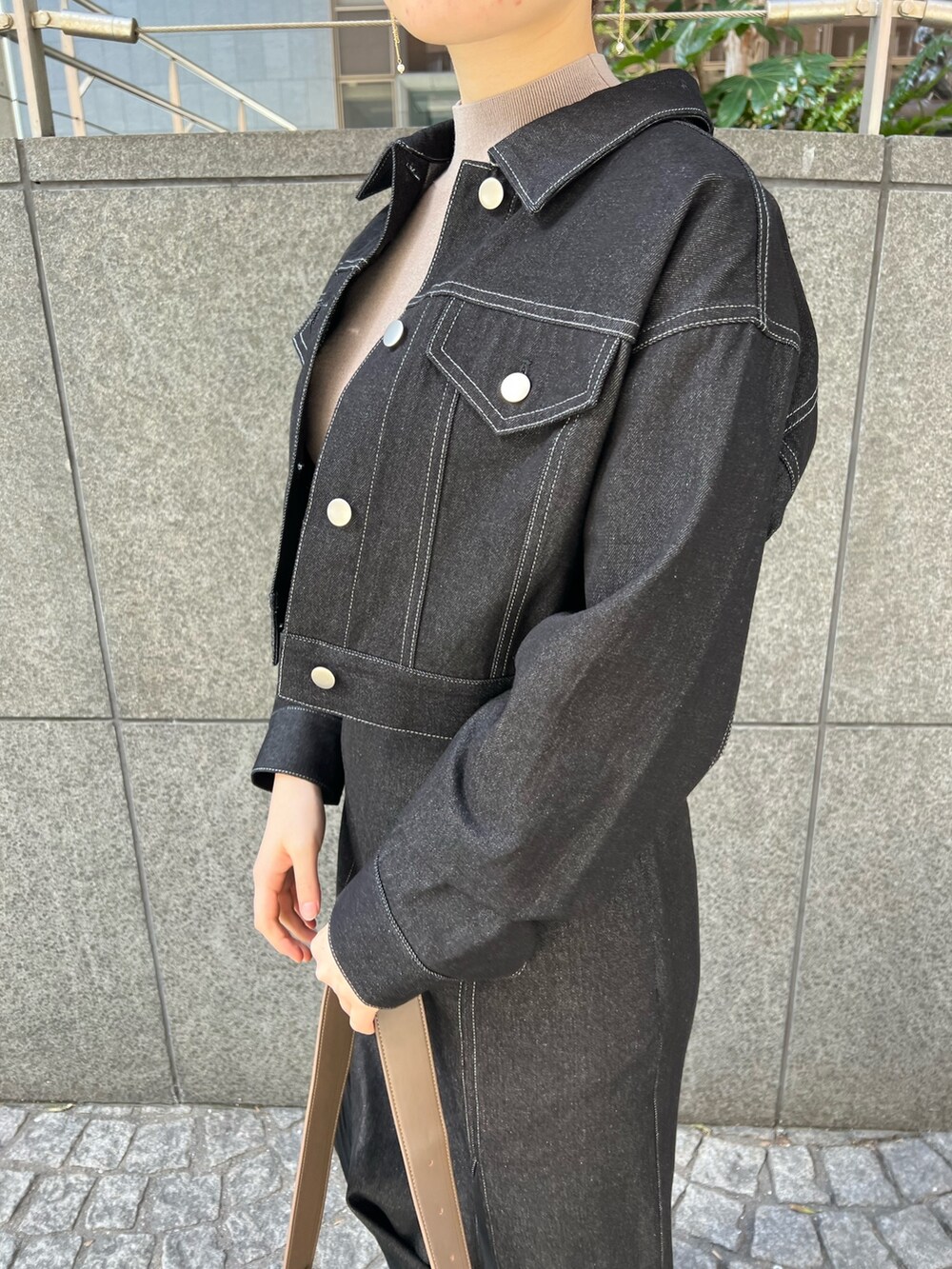 ブラック系のデニムスカート、ベージュ系のショルダーバッグ、レッド系のブーツを着用したレディースの冬コーディネートの4枚目の写真