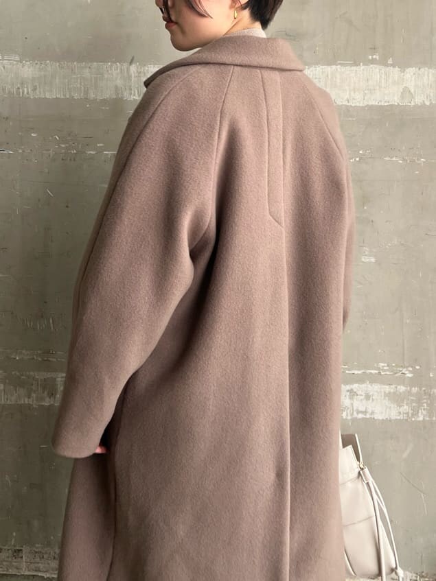 レッド系のブーツ、ベージュ系のワンピース、ホワイト系のハンドバッグを着用したレディースの秋コーディネートの4枚目の写真