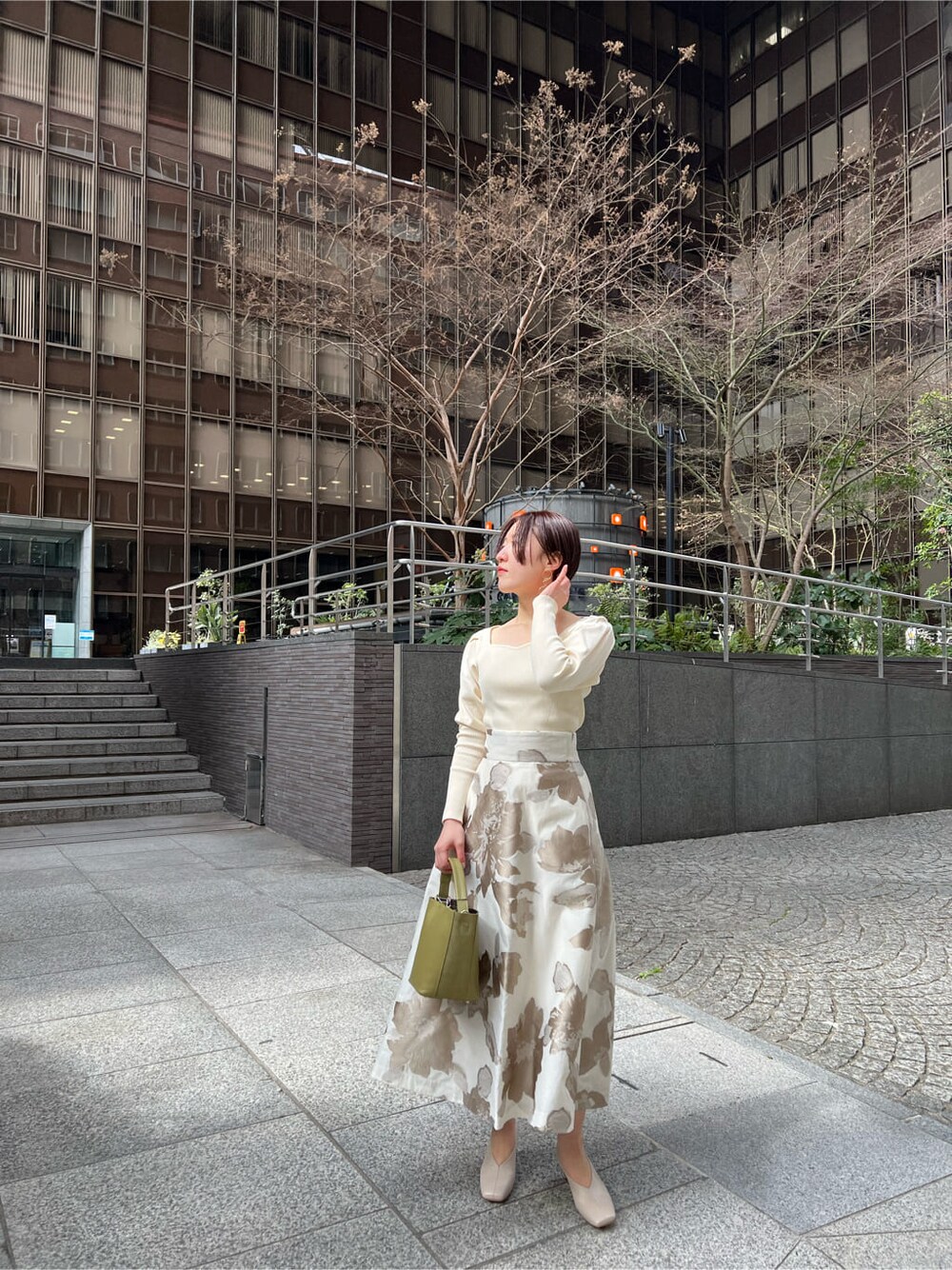 イエロー系のその他アウター、ベージュ系のスカート、ホワイト系のニット/セーターを着用したレディースの冬コーディネートの4枚目の写真