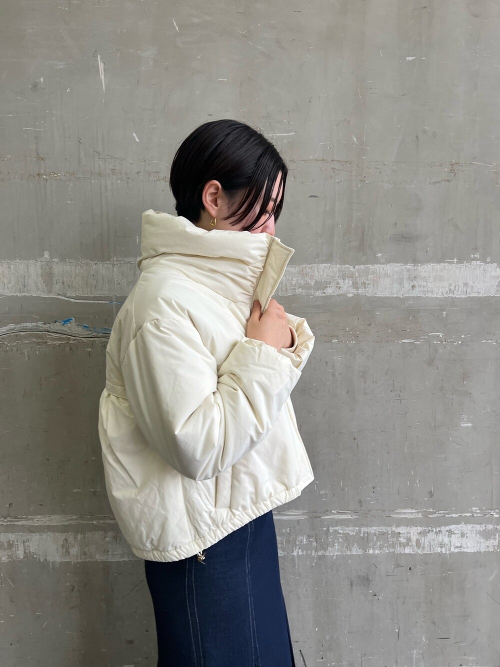 ベージュ系のブーツ、ブルー系のスカート、ホワイト系のダウンジャケット/コートを着用したレディースの冬コーディネートの5枚目の写真