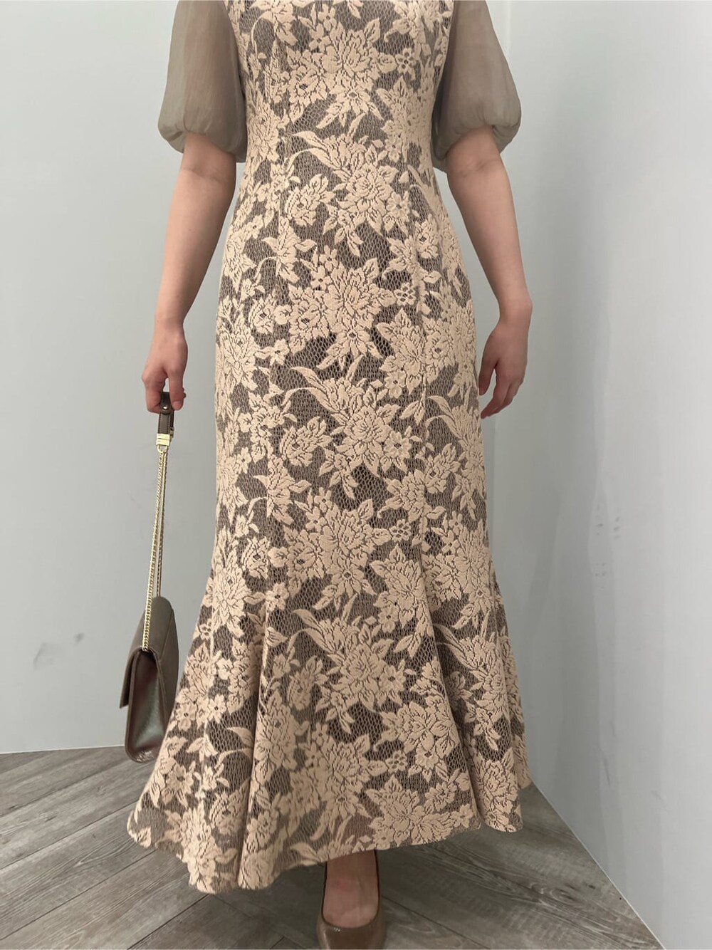 ゴールド系のクラッチバッグ、ゴールド系のパンプス、ベージュ系のドレスを着用したレディースの夏コーディネートの8枚目の写真