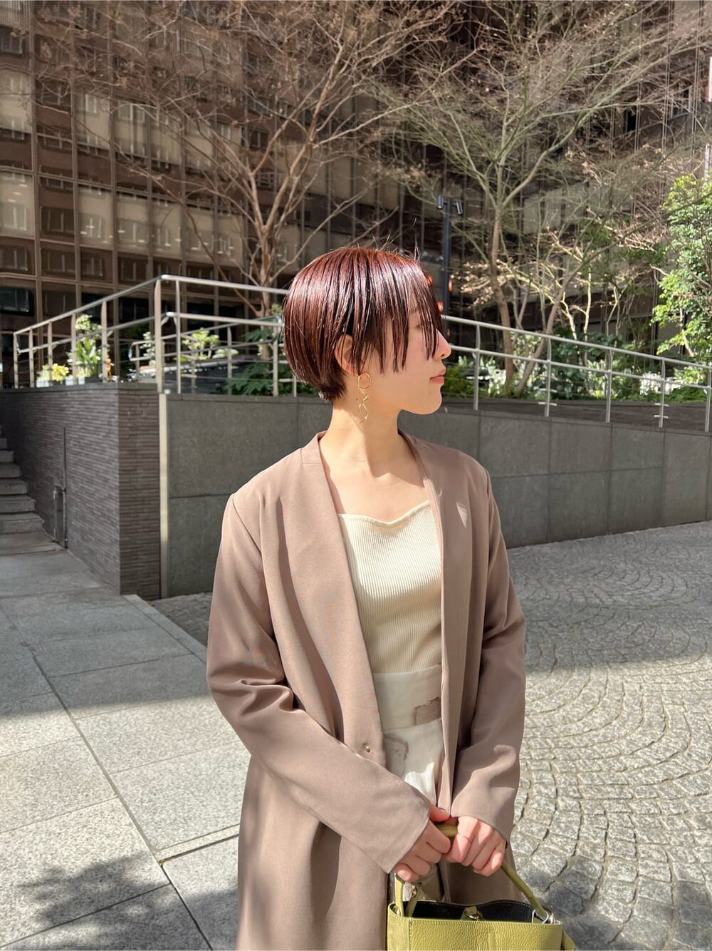 イエロー系のその他アウター、ベージュ系のスカート、ホワイト系のニット/セーターを着用したレディースの冬コーディネートの6枚目の写真