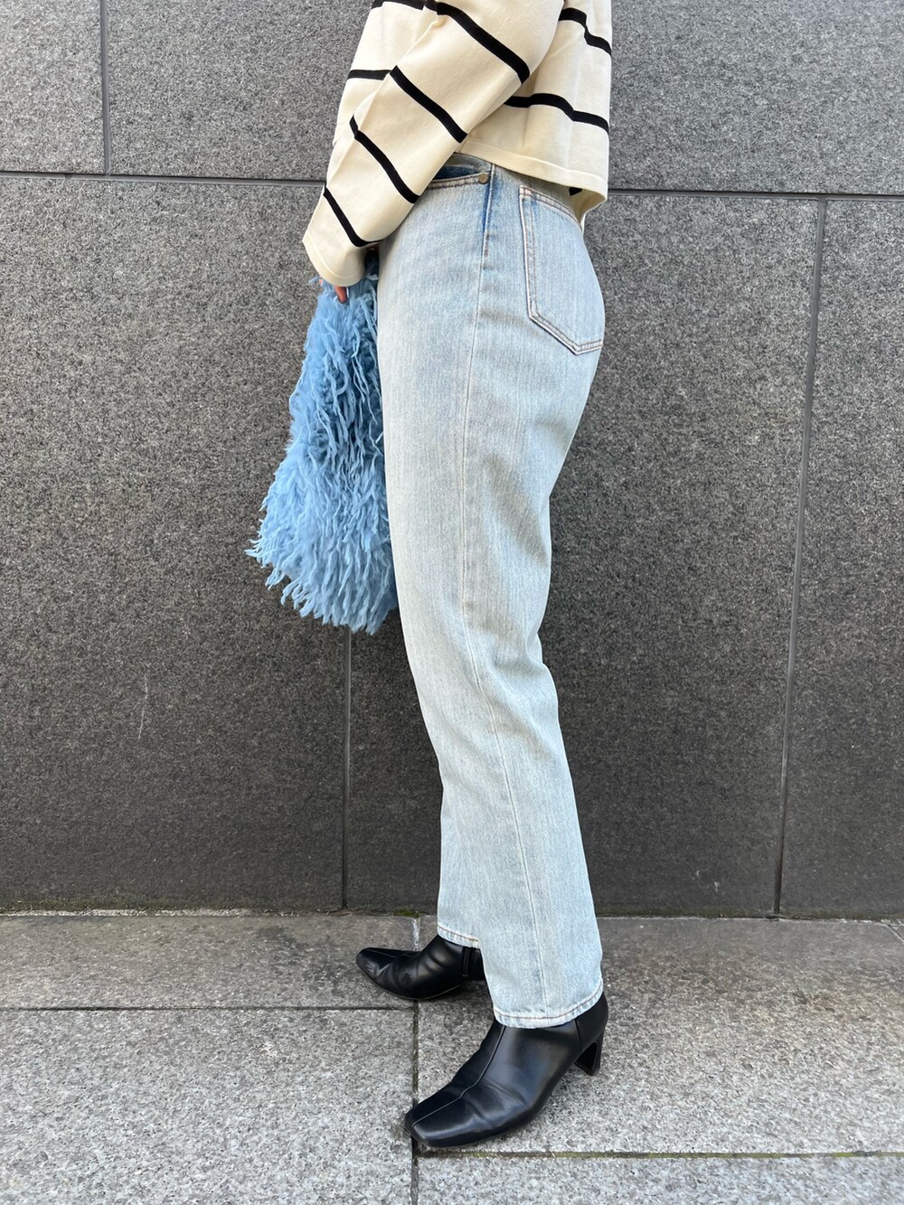 ブルー系のデニムパンツ、ホワイト系のニット/セーターを着用したレディースの冬コーディネートの8枚目の写真