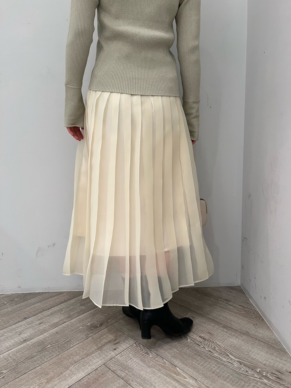 ホワイト系のスカート、グリーン系のアンサンブルを着用したレディースの冬コーディネートの7枚目の写真