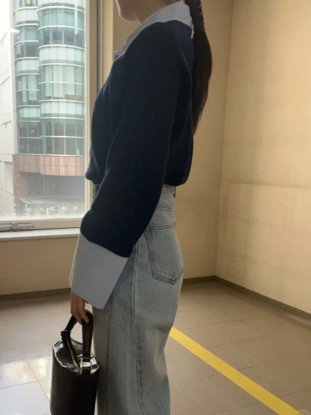 ブルー系のニット/セーター、ブルー系のデニムパンツを着用したレディースの冬コーディネートの5枚目の写真