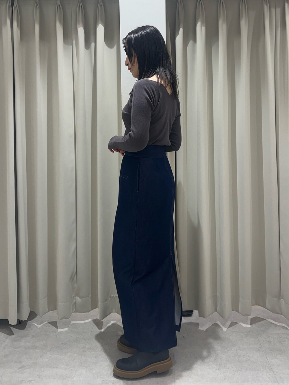 ブルー系のスカート、グレー系のニット/セーターを着用したレディースの春コーディネートの2枚目の写真