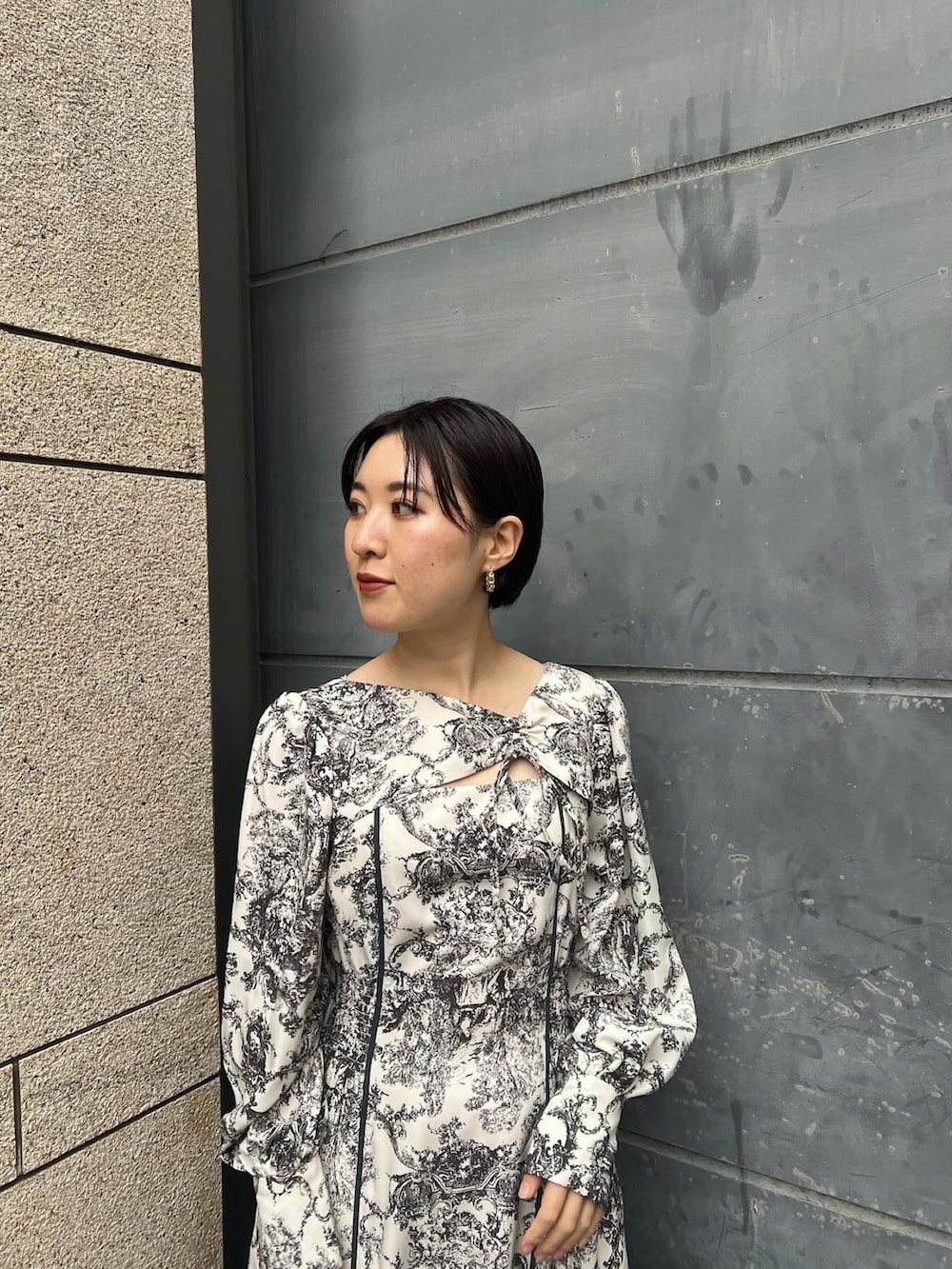 ホワイト系のノーカラーコート、ホワイト系のワンピース、ベージュ系のブーツを着用したレディースの冬コーディネートの6枚目の写真