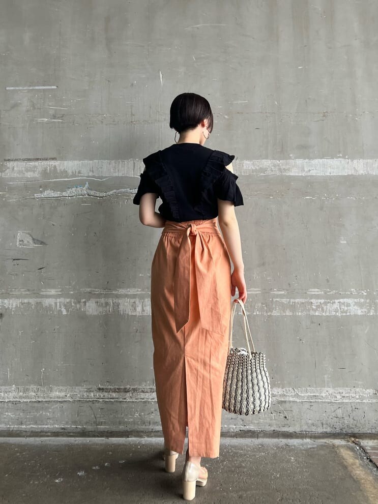 オレンジ系のスカート、その他のパンプス、ブラック系のニット/セーターを着用したレディースの春コーディネートの3枚目の写真