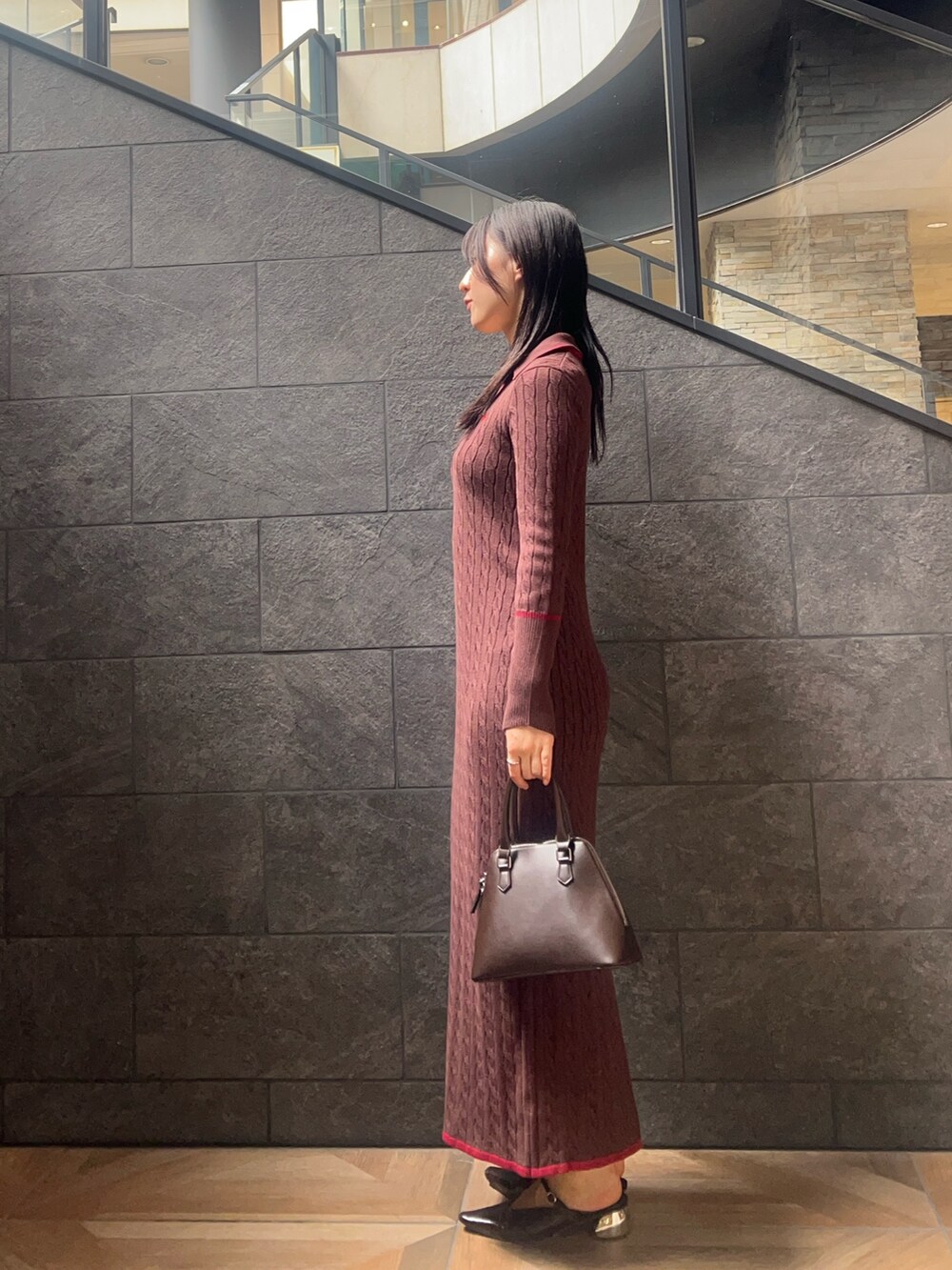 ブラウン系のワンピース、ブラウン系のボストンバッグ、ブラウン系のパンプスを着用したレディースの秋コーディネートの2枚目の写真