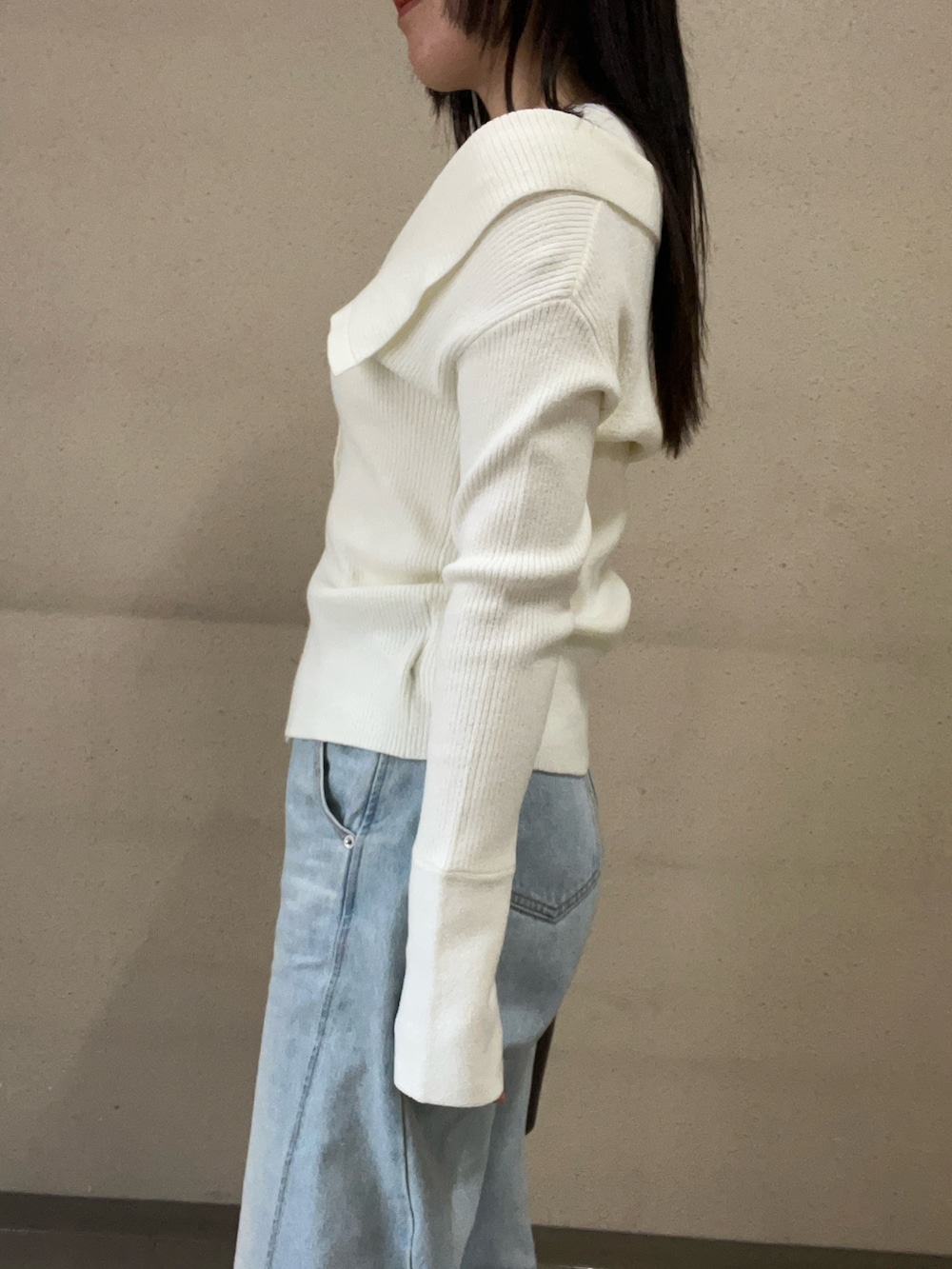 ホワイト系のアンサンブル、ブルー系のデニムパンツを着用したレディースの冬コーディネートの5枚目の写真