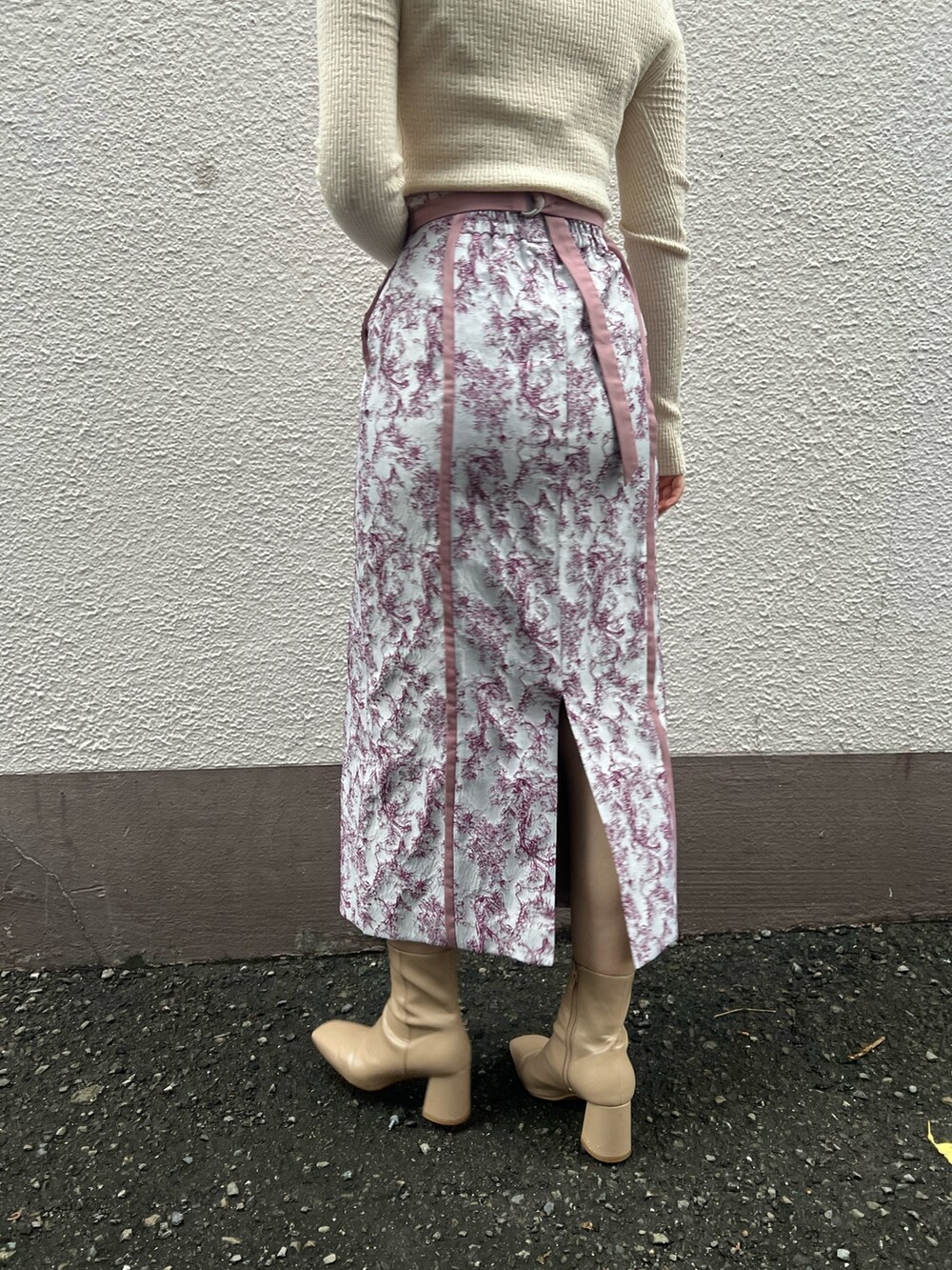 ベージュ系のブーツ、ベージュ系のその他アウター、ホワイト系のニット/セーターを着用したレディースの秋コーディネートの10枚目の写真