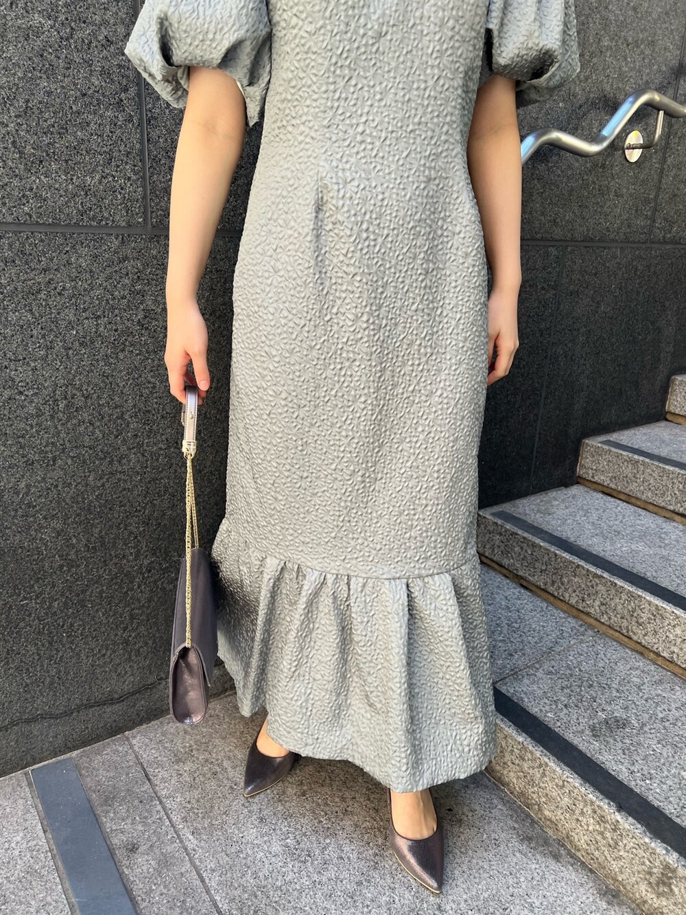 ブラック系のその他アウター、シルバー系のパンプス、グリーン系のドレスを着用したレディースの秋コーディネートの8枚目の写真