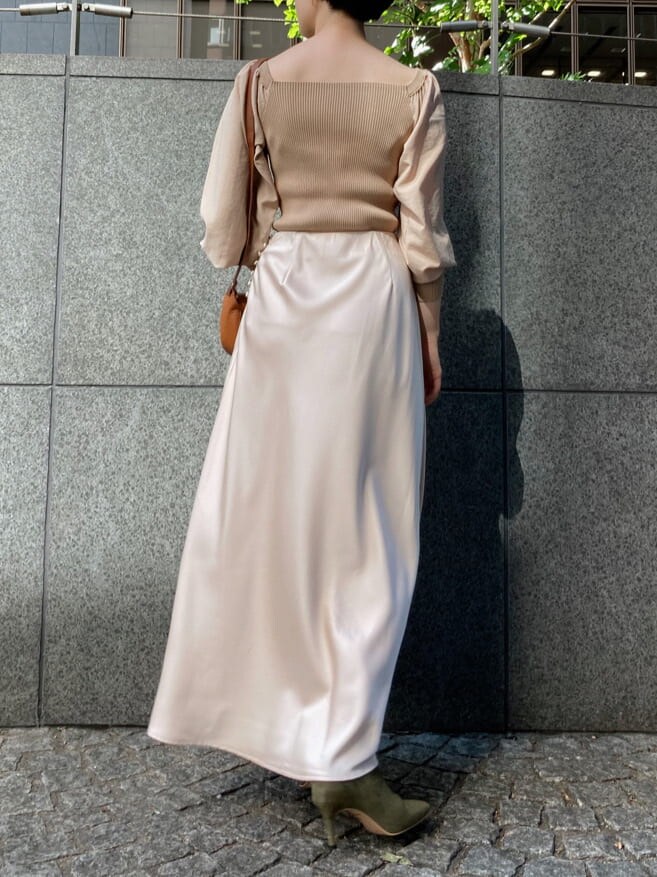 ホワイト系のスカート、ベージュ系のブーツ、ブラウン系のショルダーバッグを着用したレディースの秋コーディネートの3枚目の写真