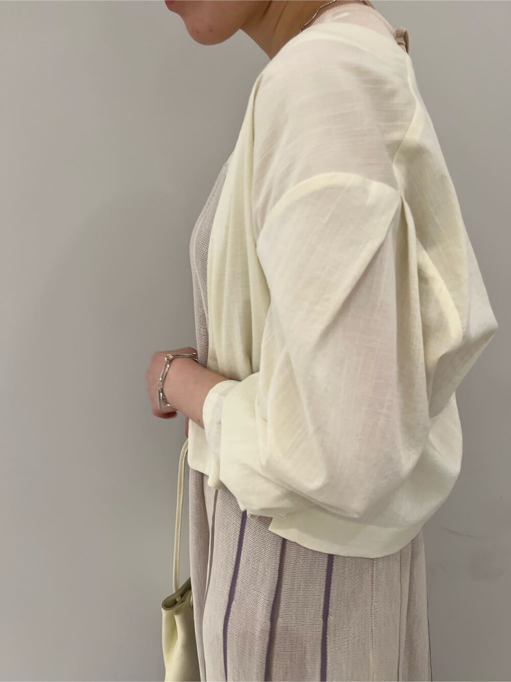 ホワイト系のノーカラージャケット、その他のパンプス、パープル系のワンピースを着用したレディースの夏コーディネートの5枚目の写真