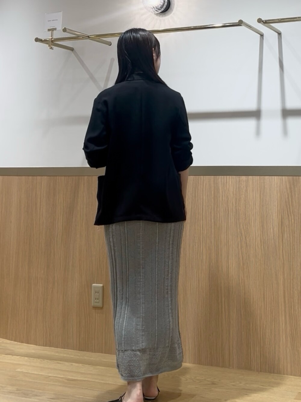 グリーン系のワンピース、ブラック系のテーラードジャケットを着用したレディースの夏コーディネートの3枚目の写真