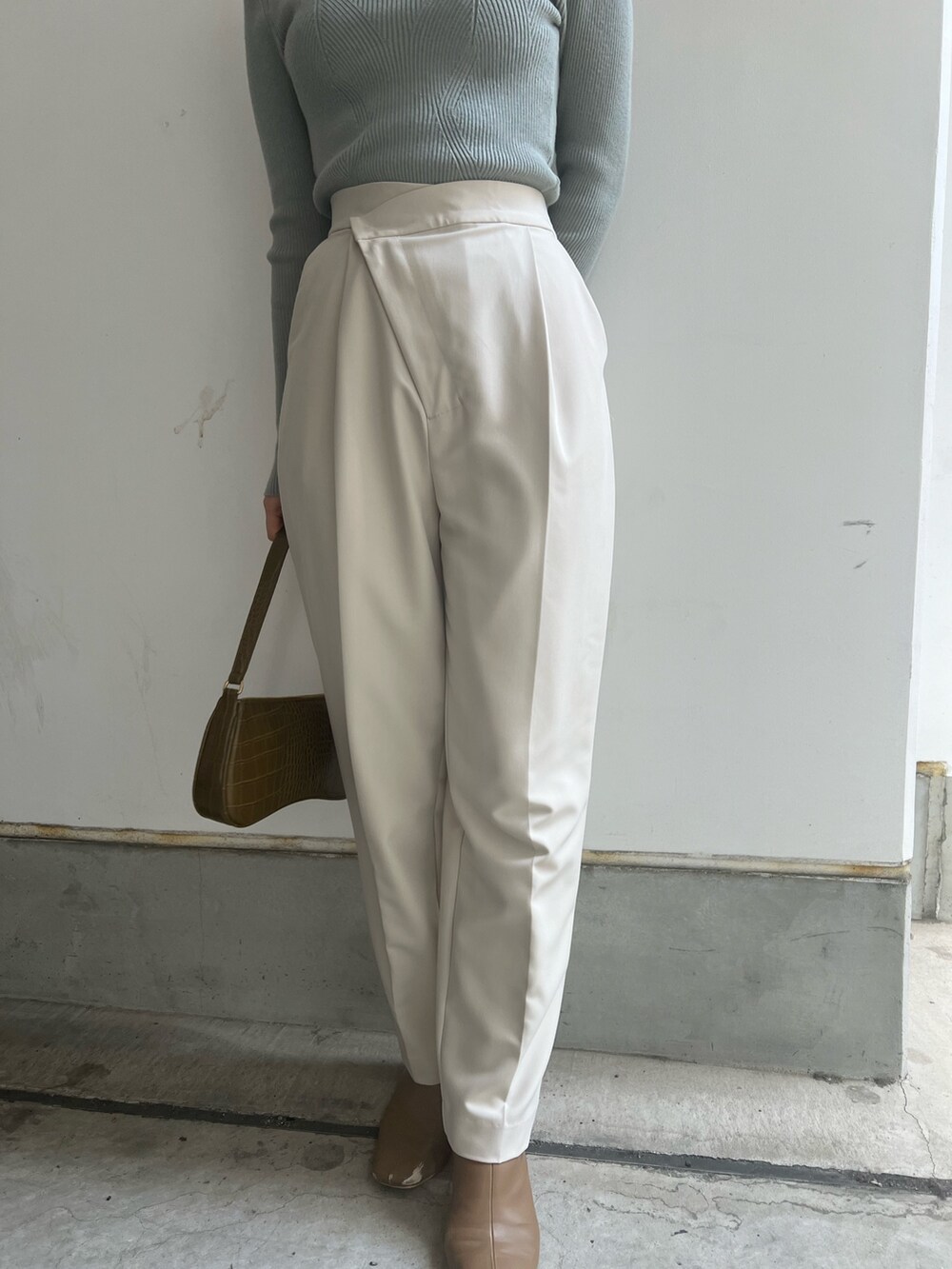 ベージュ系のブーツ、ホワイト系のスラックス、ホワイト系のニット/セーターを着用したレディースの冬コーディネートの8枚目の写真