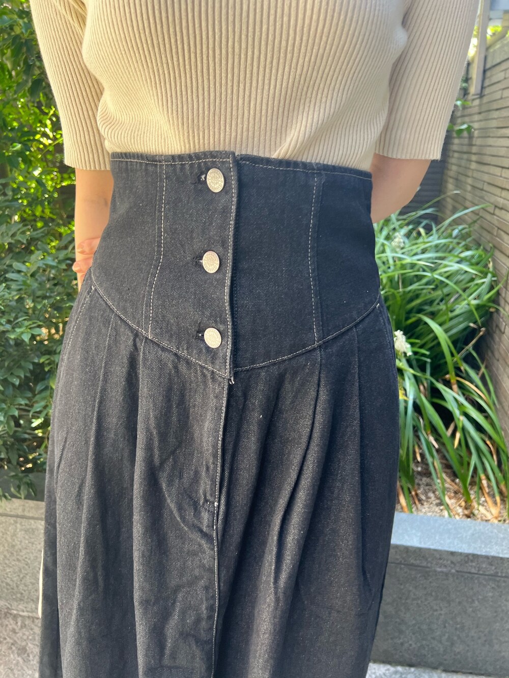 ブラック系のデニムジャケット、ブルー系のニット/セーター、ホワイト系のハンドバッグを着用したレディースの秋コーディネートの10枚目の写真