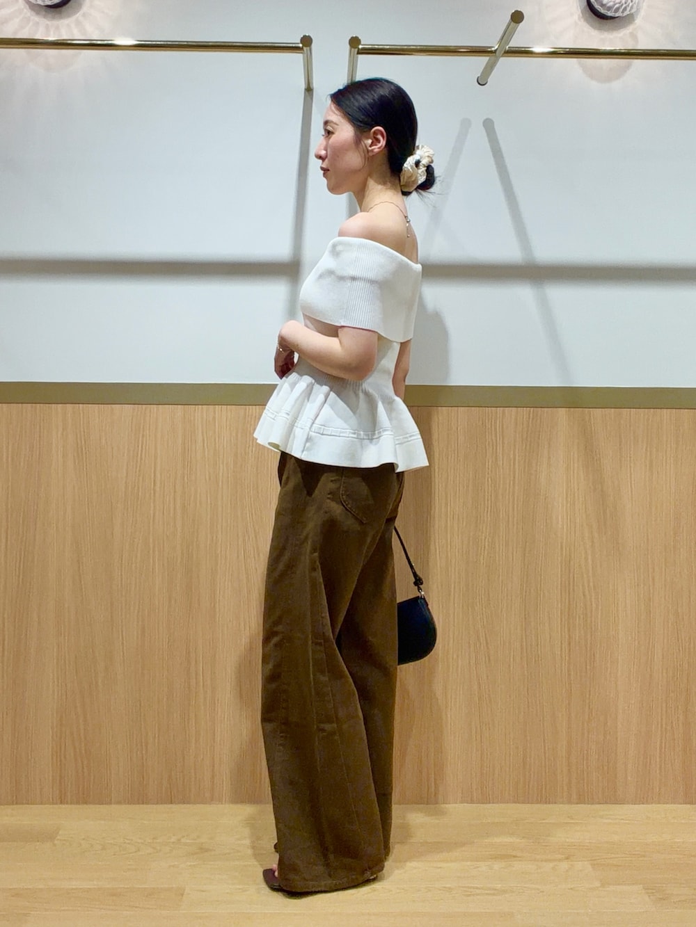 ブラウン系のデニムパンツ、ホワイト系のニット/セーター、ブラウン系のサンダルを着用したレディースの夏コーディネートの2枚目の写真