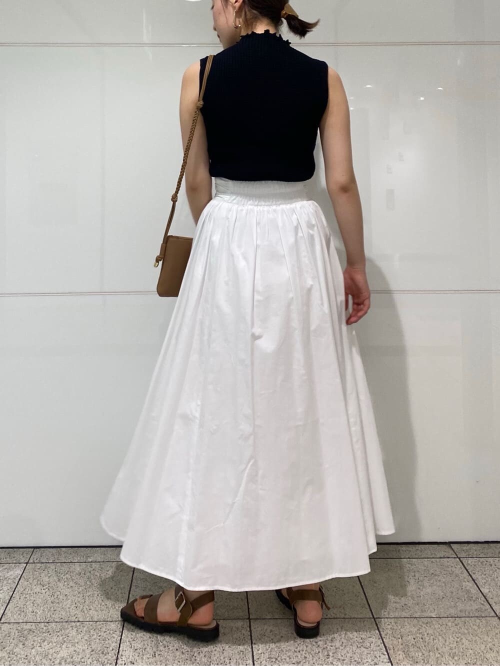 ブラウン系のサンダル、ブラック系のニット/セーター、ベージュ系のショルダーバッグを着用したレディースの夏コーディネートの3枚目の写真