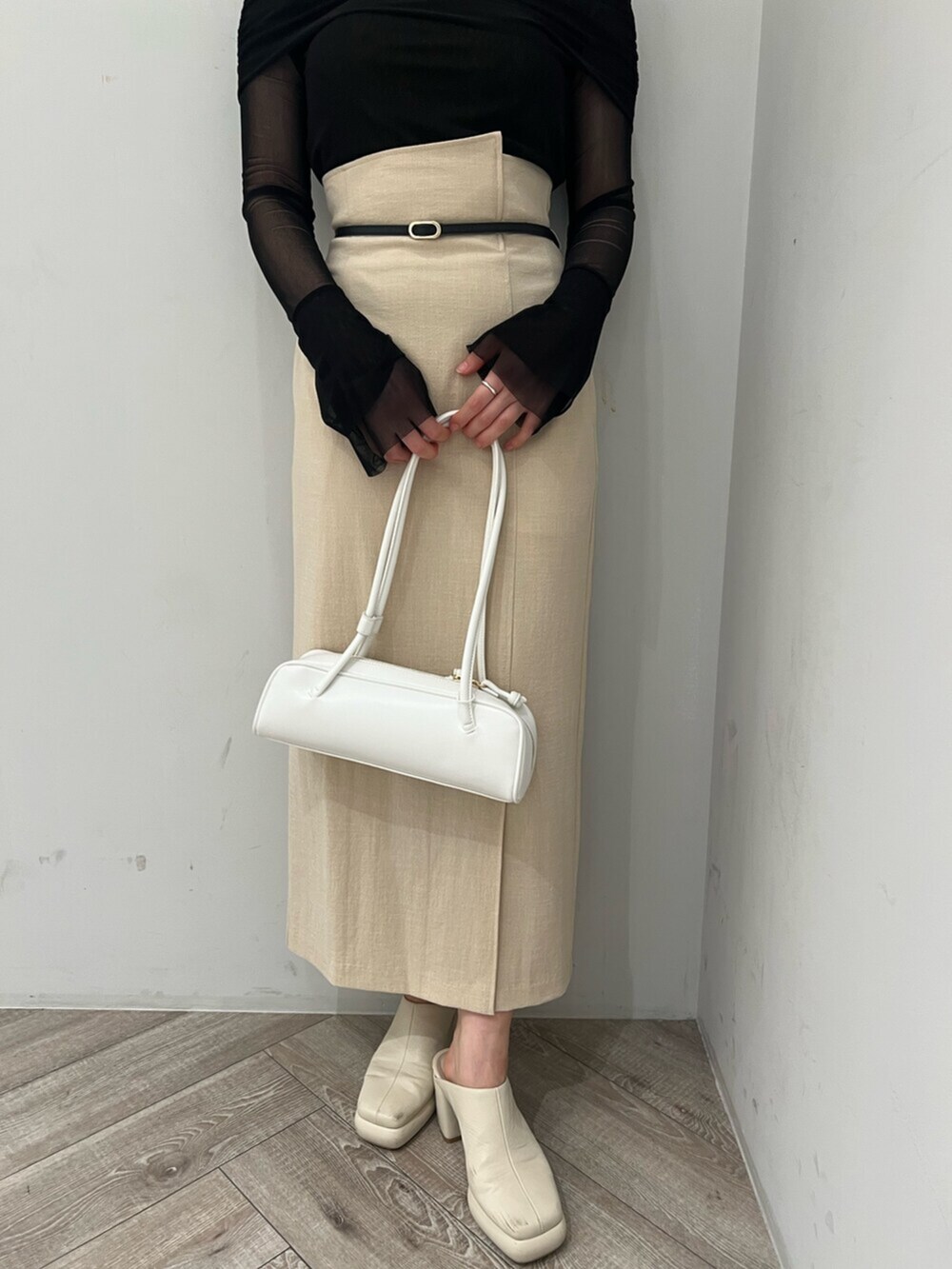 ホワイト系のサンダル、ベージュ系のスカート、ブラック系のTシャツ/カットソーを着用したレディースの春コーディネートの6枚目の写真