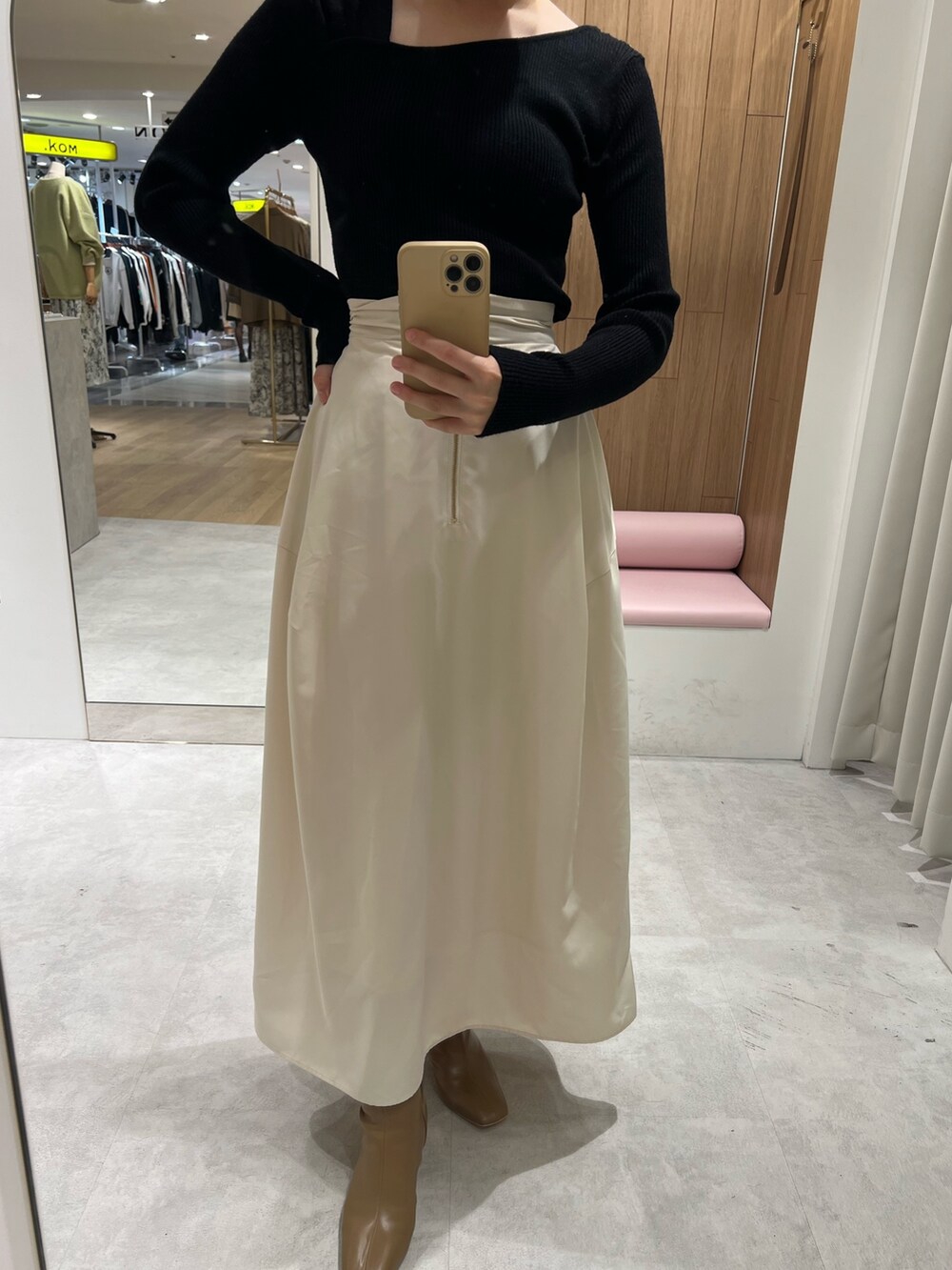 ホワイト系のスカート、ブラック系のニット/セーター、ベージュ系のブーツを着用したレディースの秋コーディネートの4枚目の写真