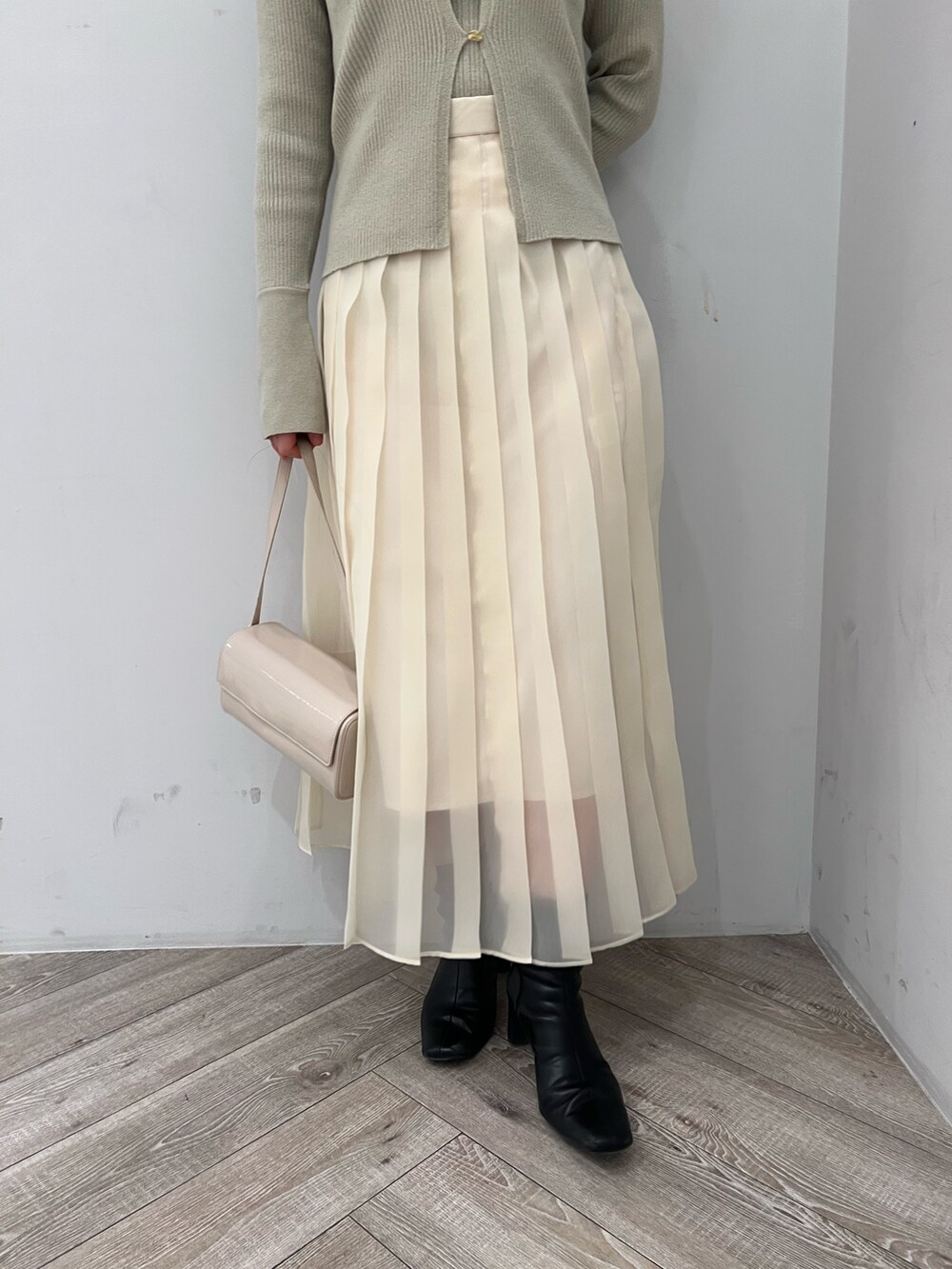 ホワイト系のスカート、グリーン系のアンサンブルを着用したレディースの冬コーディネートの6枚目の写真