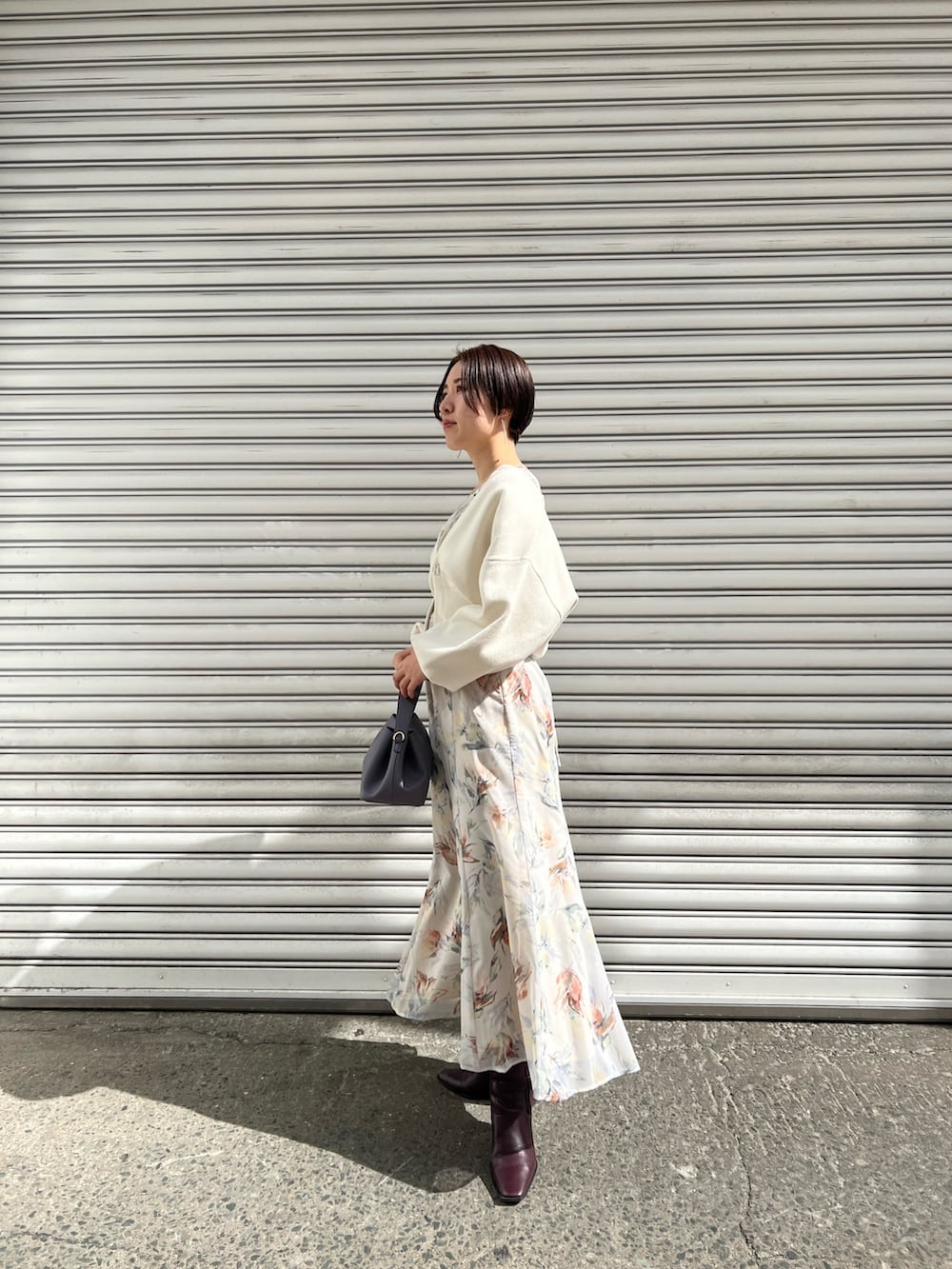 レッド系のブーツ、パープル系のハンドバッグ、ホワイト系のカーディガン/ボレロを着用したレディースの冬コーディネートの2枚目の写真