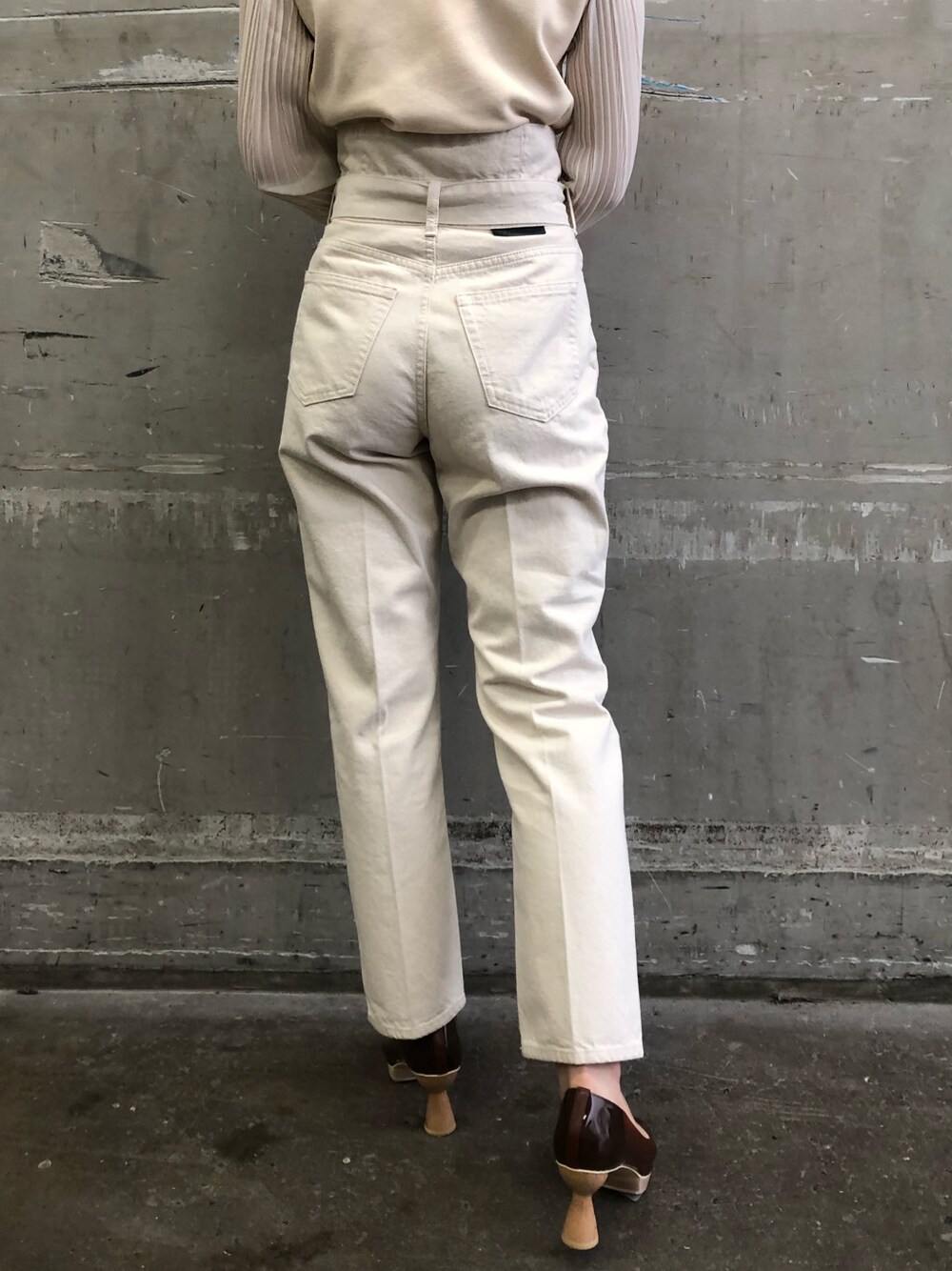 ブラウン系のパンプス、パープル系のハンドバッグ、ホワイト系のニット/セーターを着用したレディースの冬コーディネートの5枚目の写真