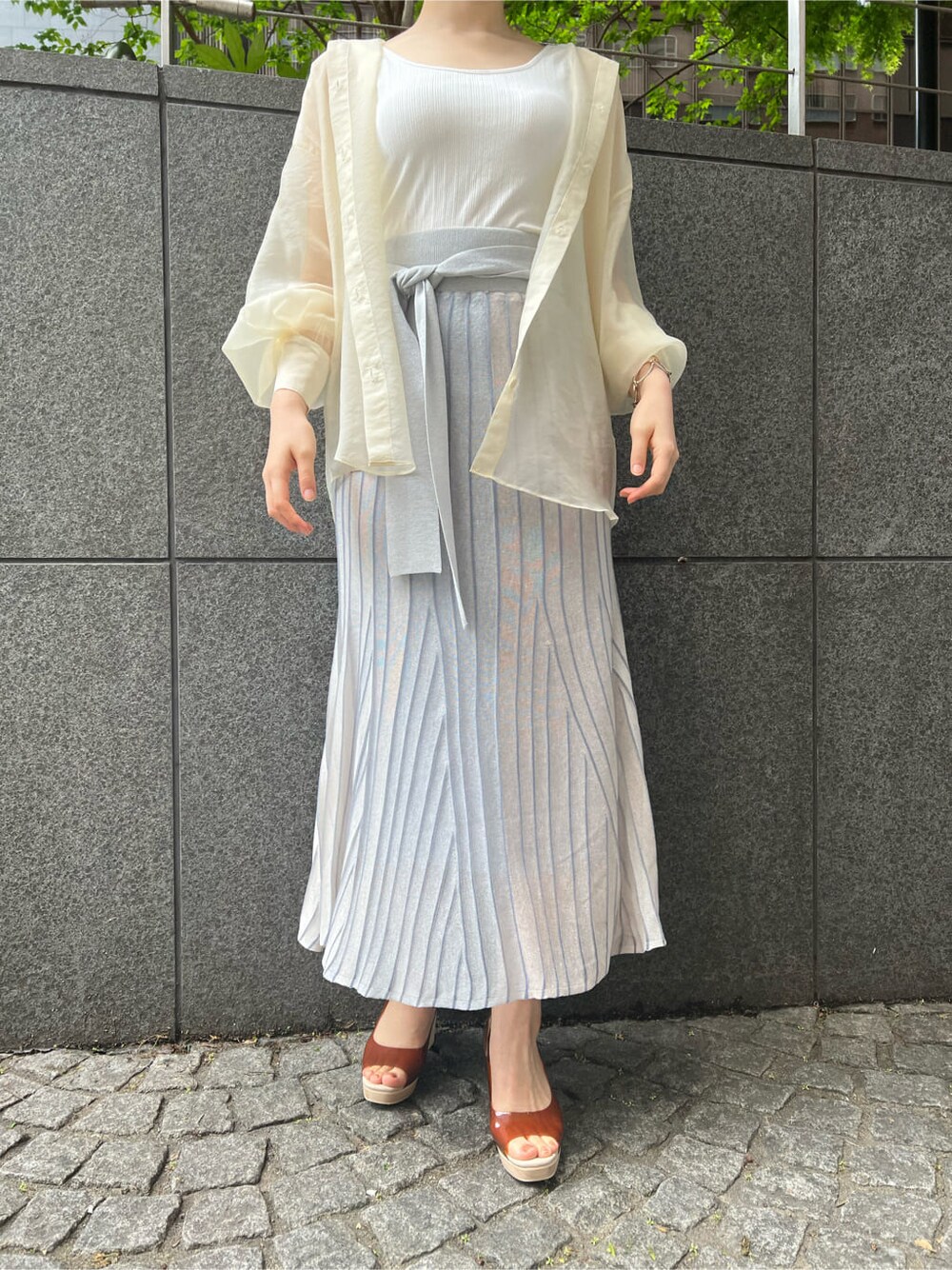 ホワイト系のシャツ/ブラウス、ブルー系のスカート、ブラウン系のパンプスを着用したレディースの春コーディネートの4枚目の写真