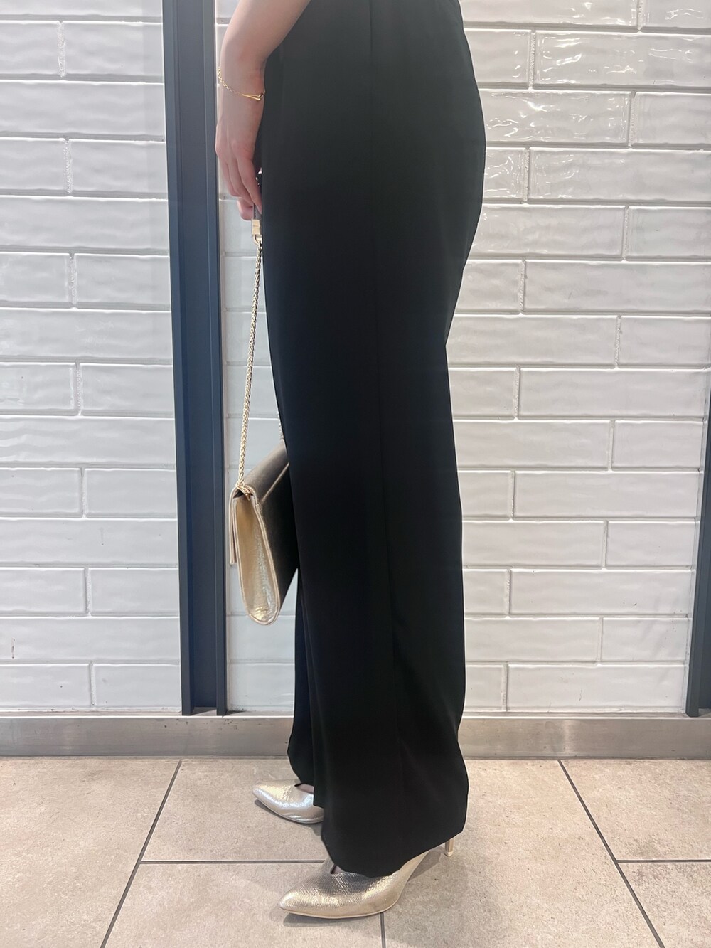 その他のパンツドレス、ゴールド系のパンプス、ゴールド系のクラッチバッグを着用したレディースの春コーディネートの7枚目の写真
