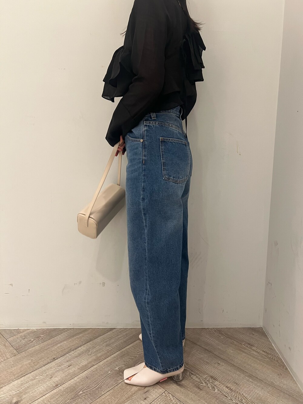 ブルー系のデニムパンツ、ブラック系のシャツ/ブラウスを着用したレディースの冬コーディネートの6枚目の写真