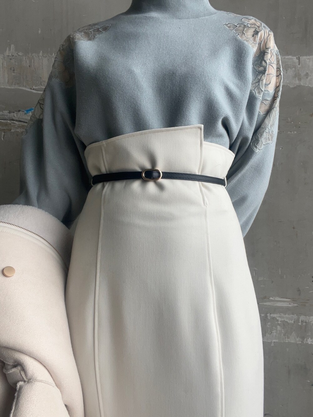 ベージュ系のブーツ、ホワイト系のハンドバッグ、ホワイト系のムートンコートを着用したレディースの秋コーディネートの8枚目の写真