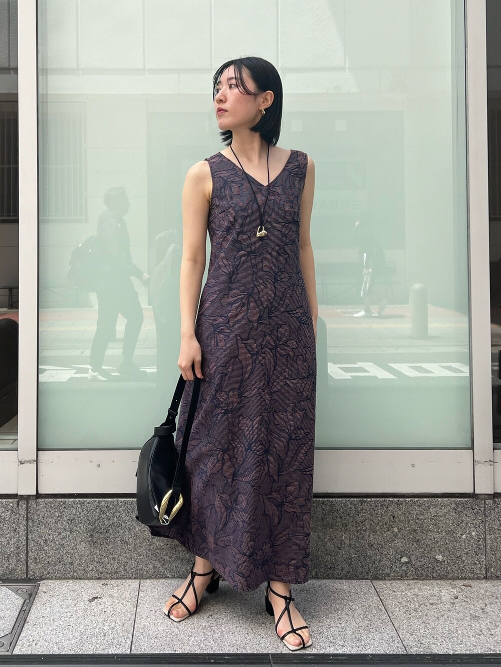 ブラック系のサンダル、ブラック系のワンピース、ホワイト系のシャツ/ブラウスを着用したレディースの春コーディネートの5枚目の写真