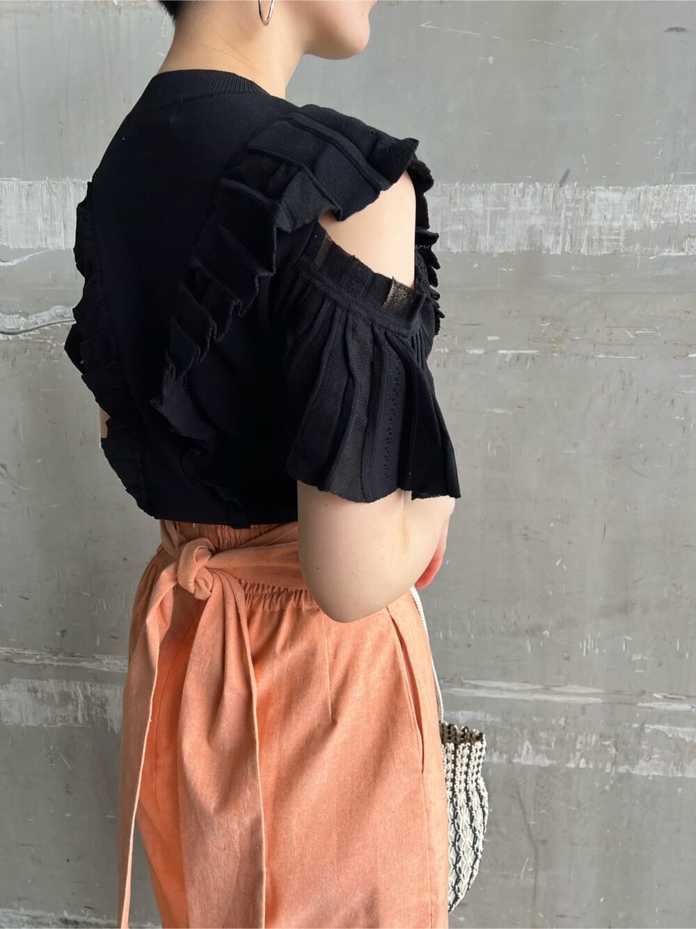 オレンジ系のスカート、その他のパンプス、ブラック系のニット/セーターを着用したレディースの春コーディネートの7枚目の写真