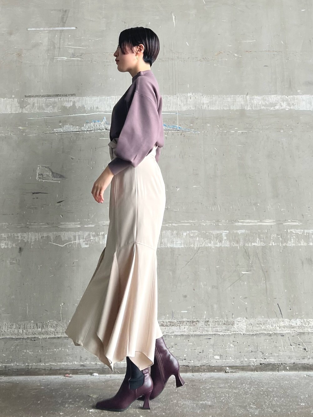 ホワイト系のノーカラーコート、ベージュ系のニット/セーター、ブラウン系のスカートを着用したレディースの秋コーディネートの5枚目の写真