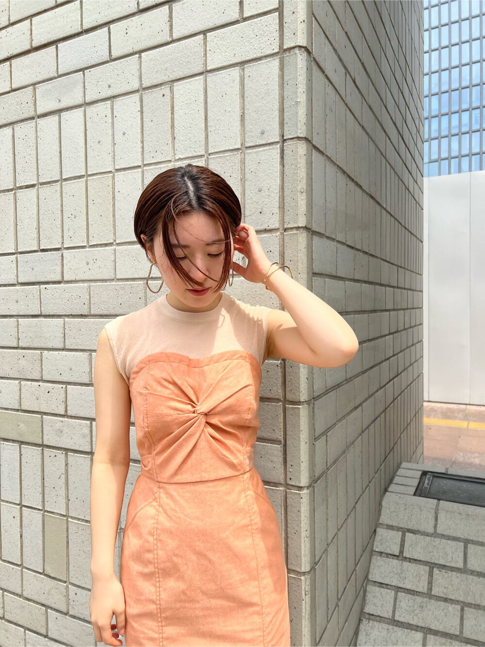 ホワイト系のブルゾン、オレンジ系のワンピース、ホワイト系のサンダルを着用したレディースの春コーディネートの7枚目の写真