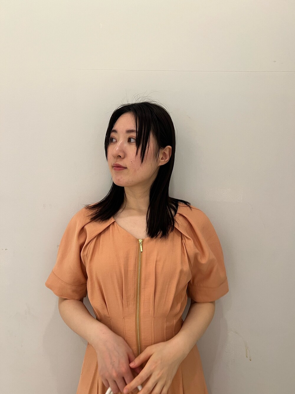 オレンジ系のワンピース、ホワイト系のサンダルを着用したレディースの春コーディネートの4枚目の写真