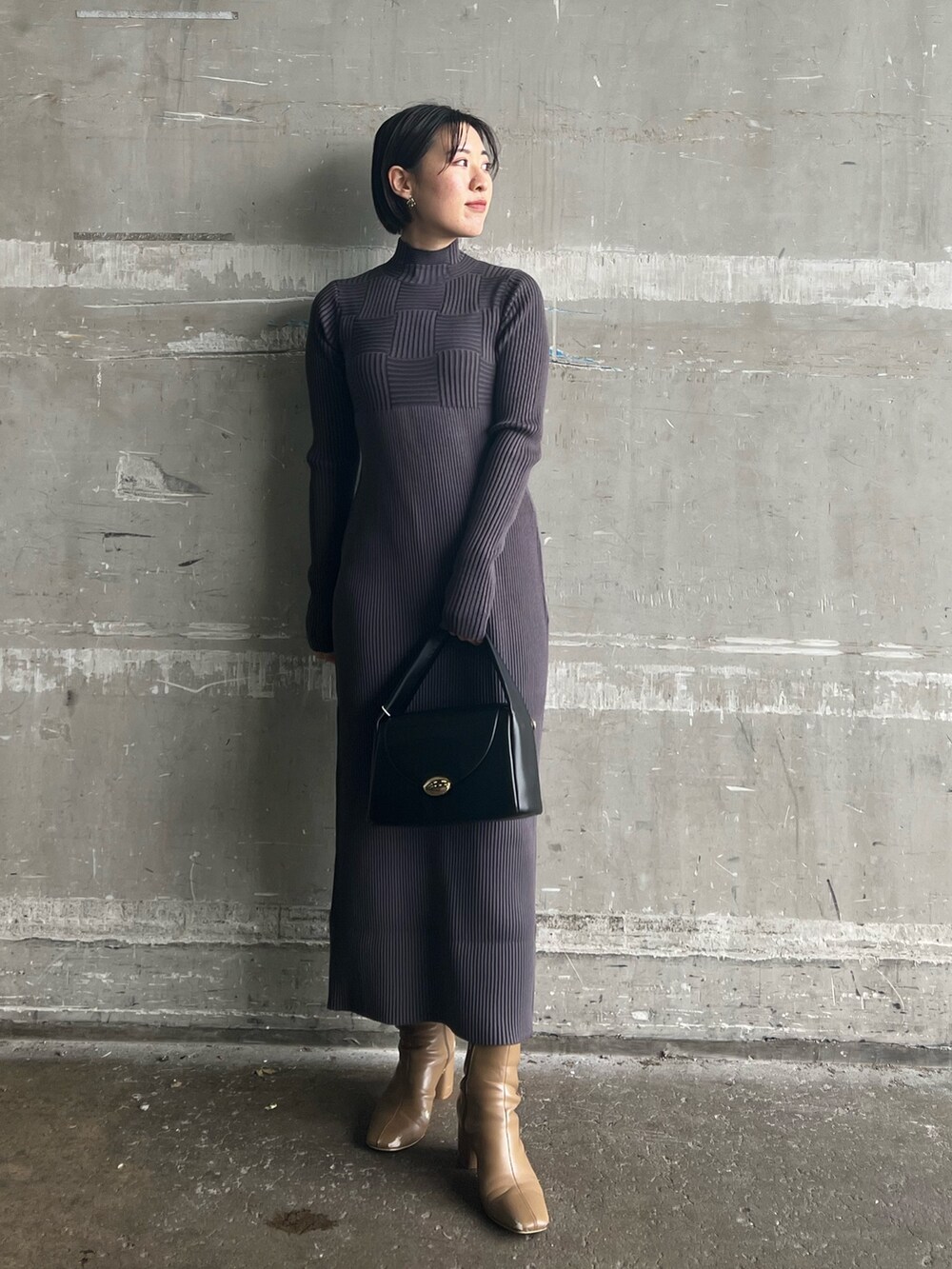 ブラック系のハンドバッグ、ベージュ系のブーツ、ホワイト系のカーディガン/ボレロを着用したレディースの冬コーディネートの3枚目の写真